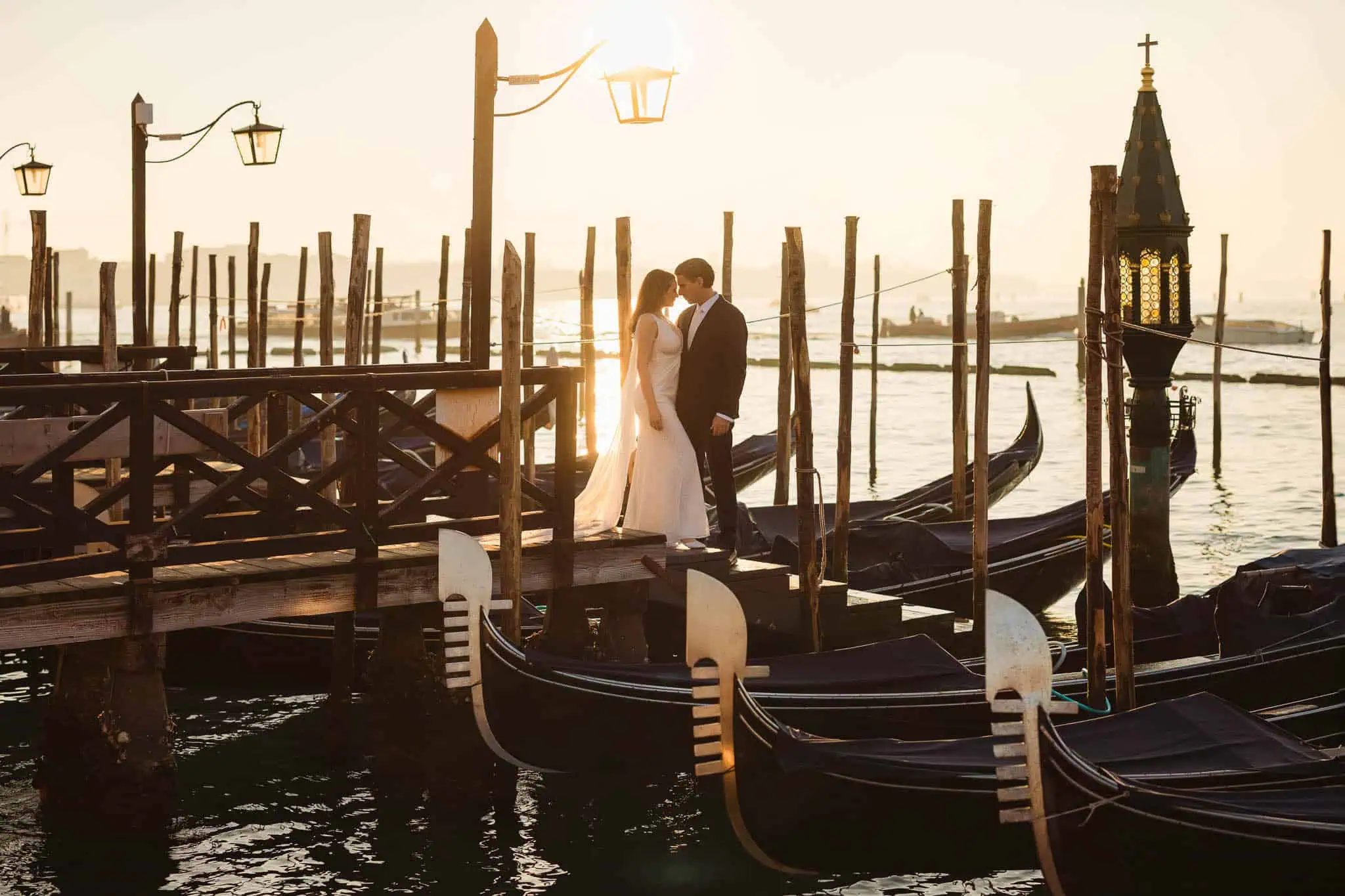 Romantic wedding photo of couple on gondola dock in Venice at sunset, Venice Wedding Photography in Italy.