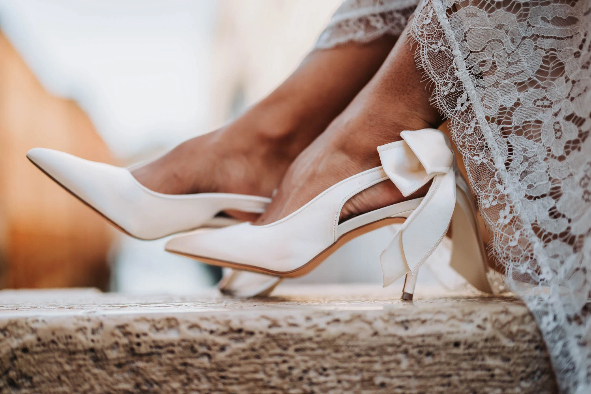 Elegant white wedding shoes with lace trim and bows, perfect for a romantic Venice wedding.