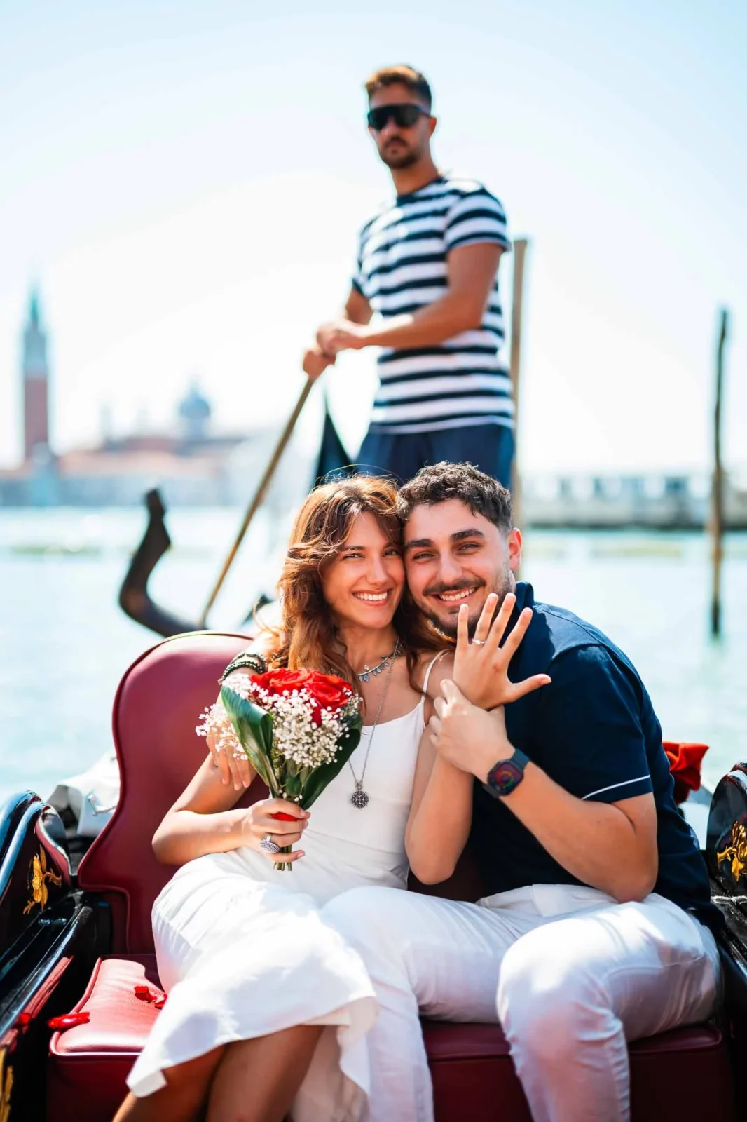Couple on gondola with bouquet.