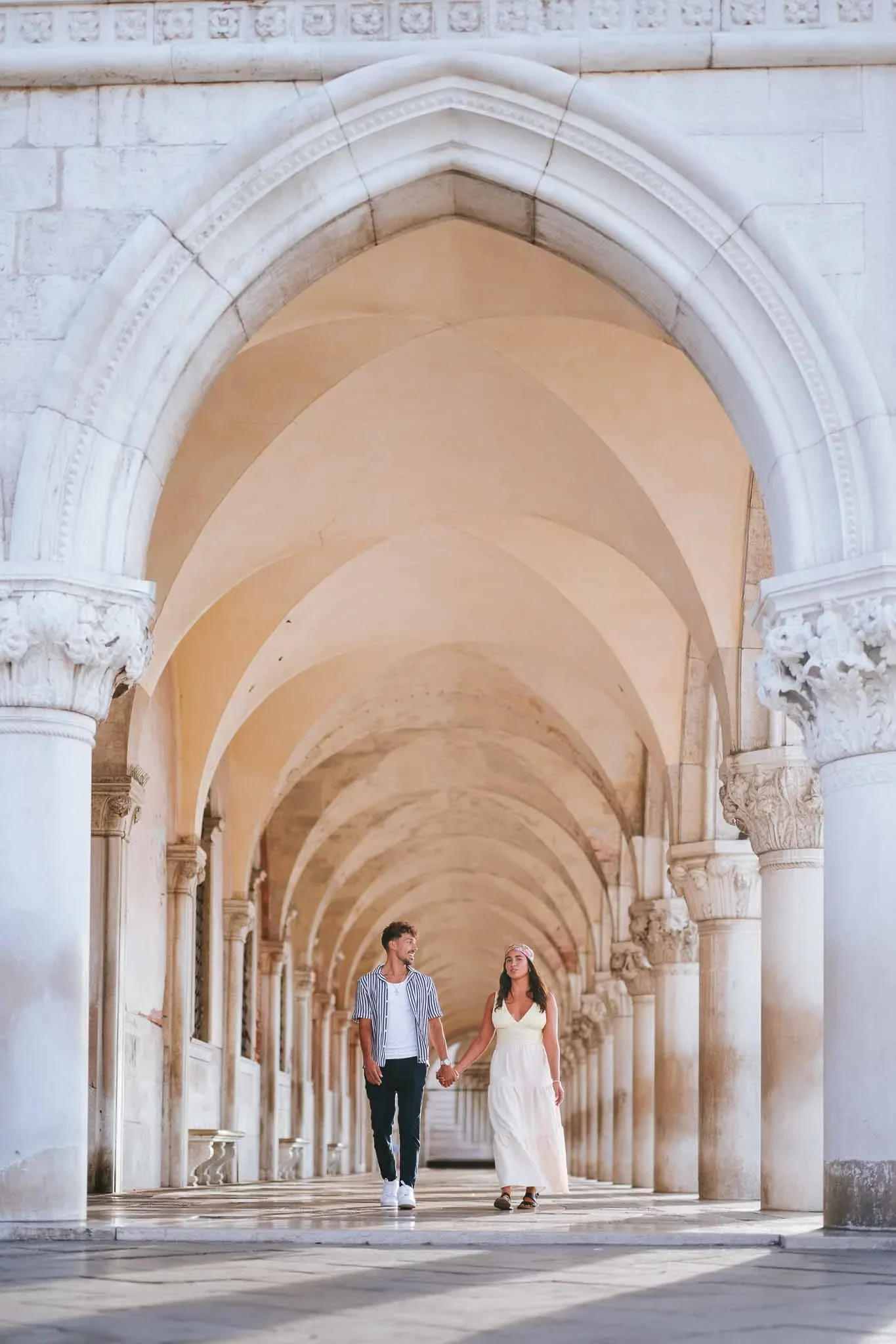1. Romantic couple walking hand in hand through Venice historic architecture.