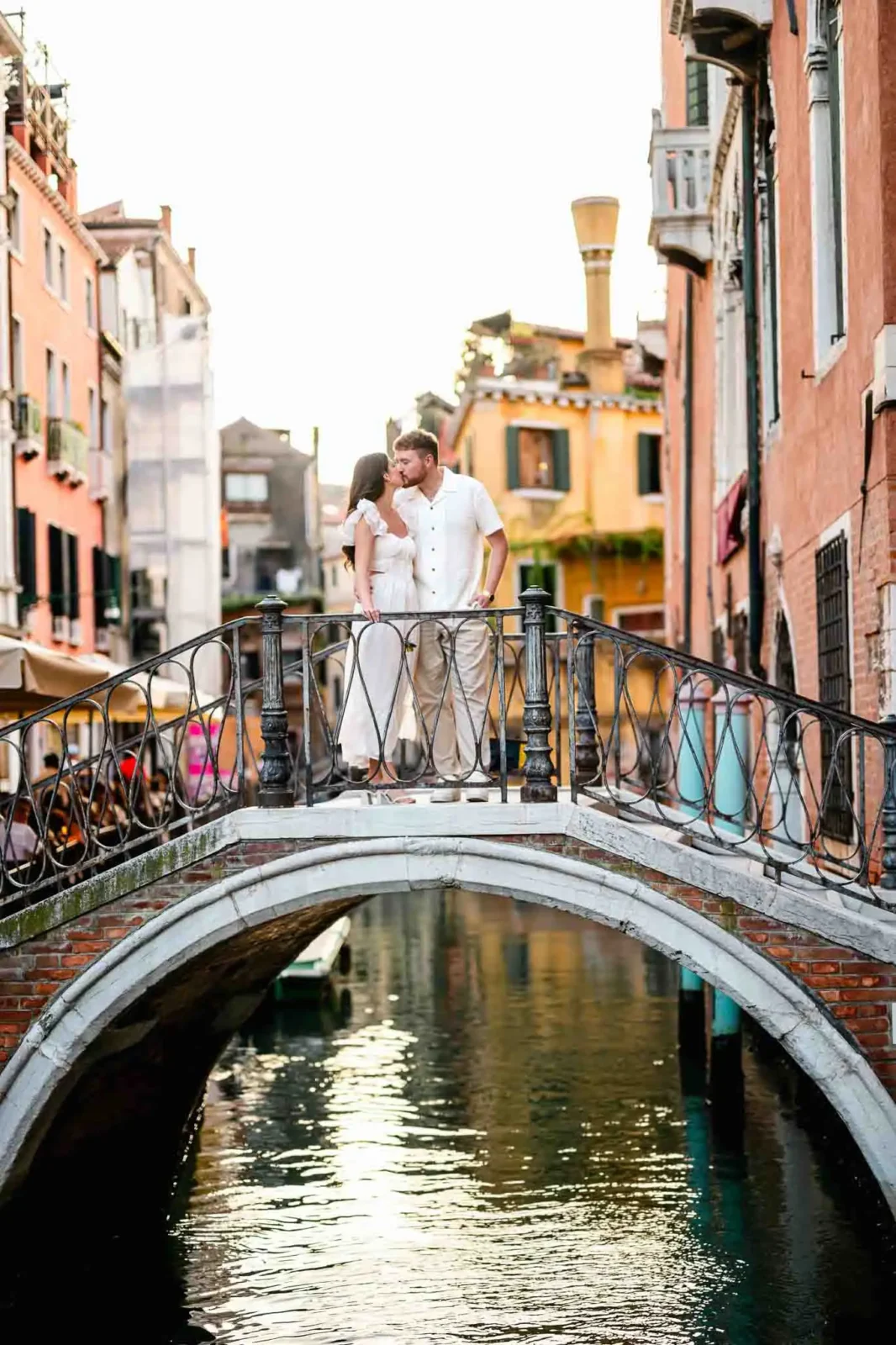 Romantic couple on Venice bridge during sunset, perfect for engagement photos.