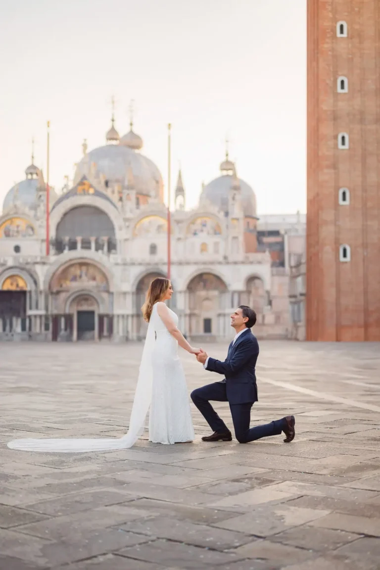 A couple getting engaged in Venice, with historical architecture in the background.