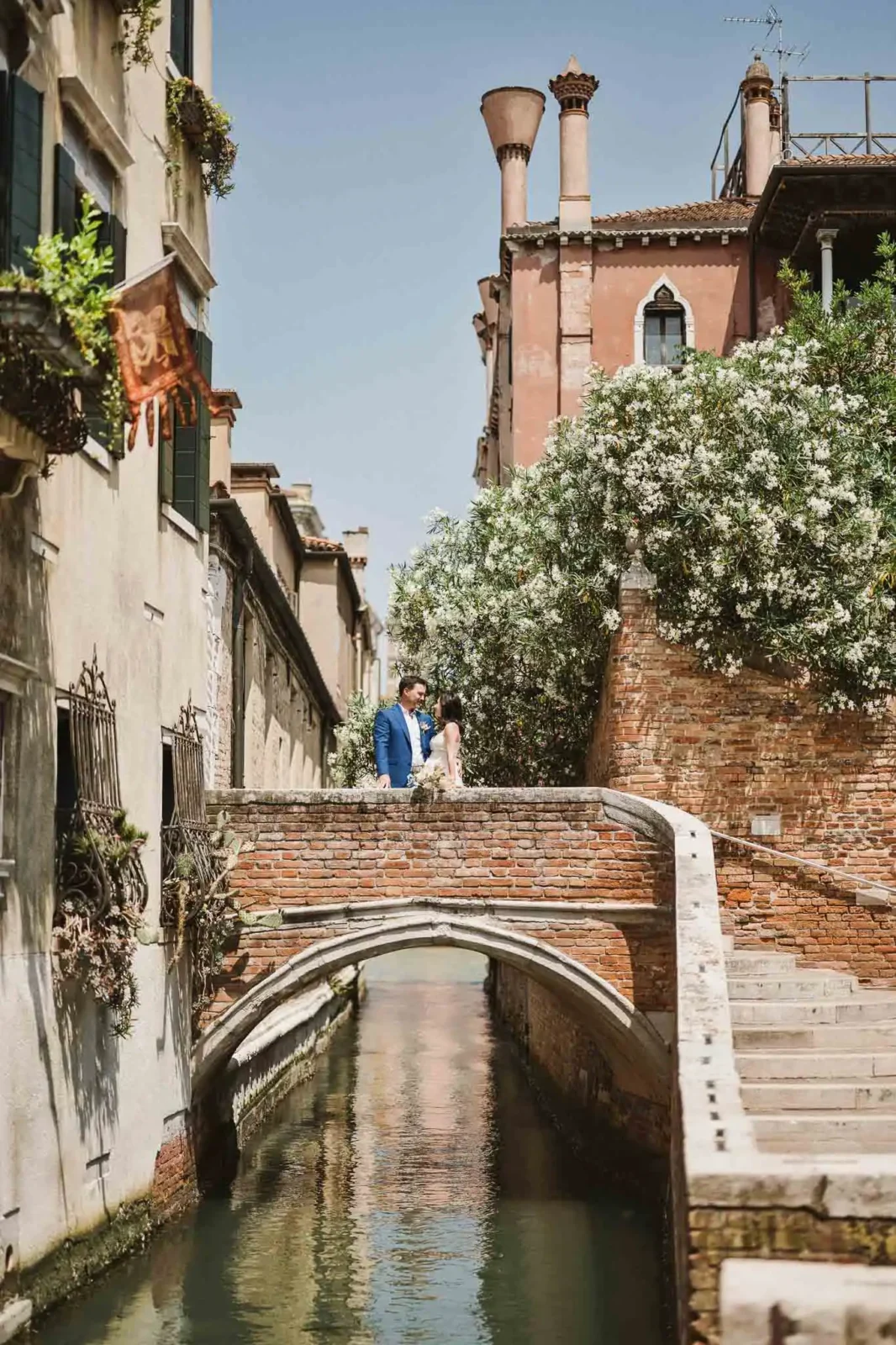 1. Romantic couple in Venice near a canal on a sunny day, perfect for wedding and engagement photos.