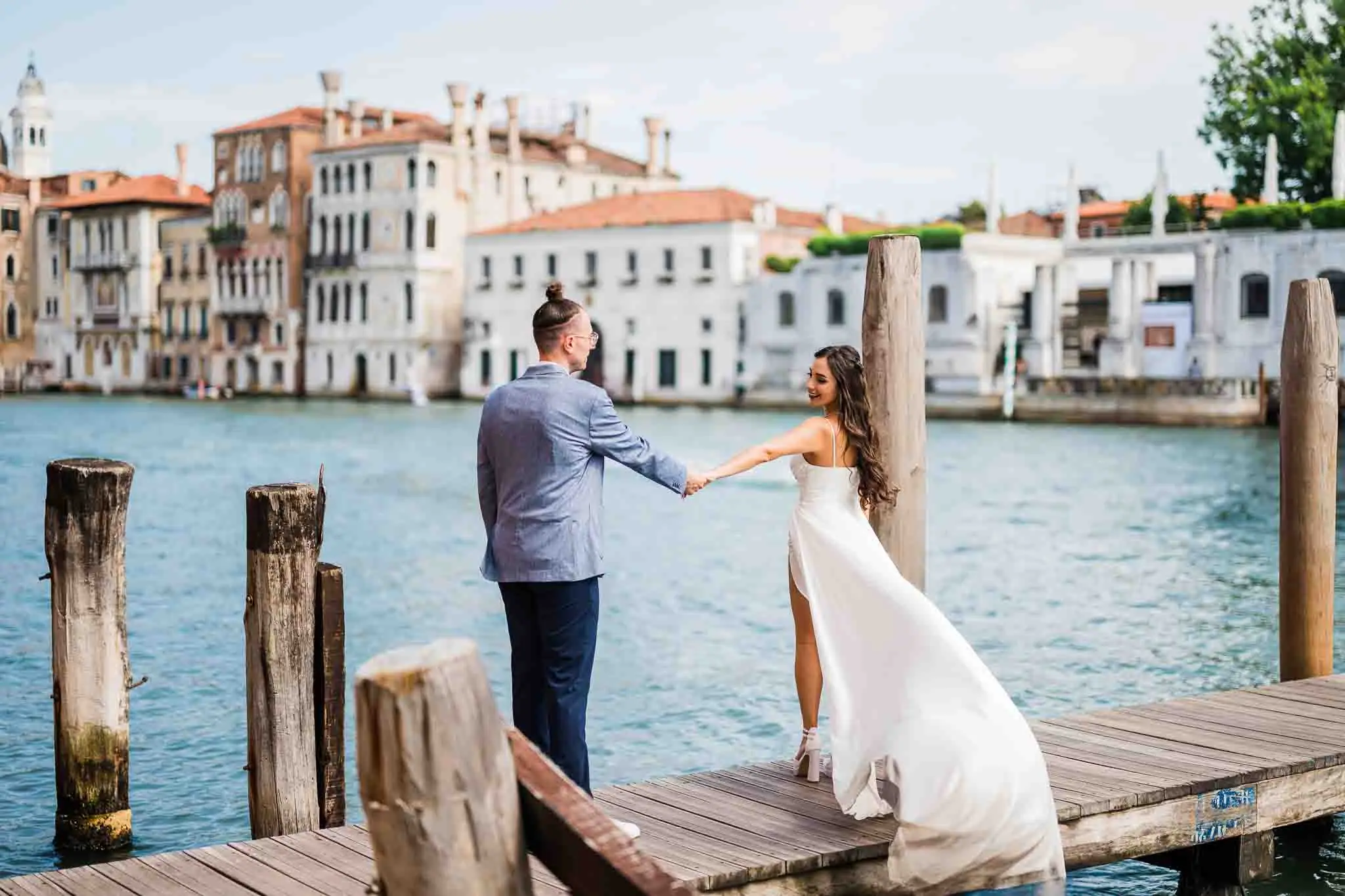 1. Romantic wedding proposal on Venice waterfront with bride and groom holding hands.