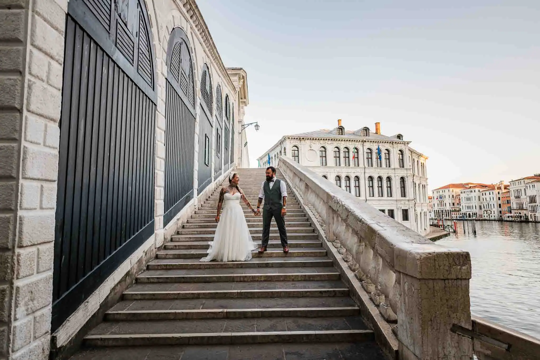 1. Romantic Venice wedding couple walking hand in hand on historic staircase.