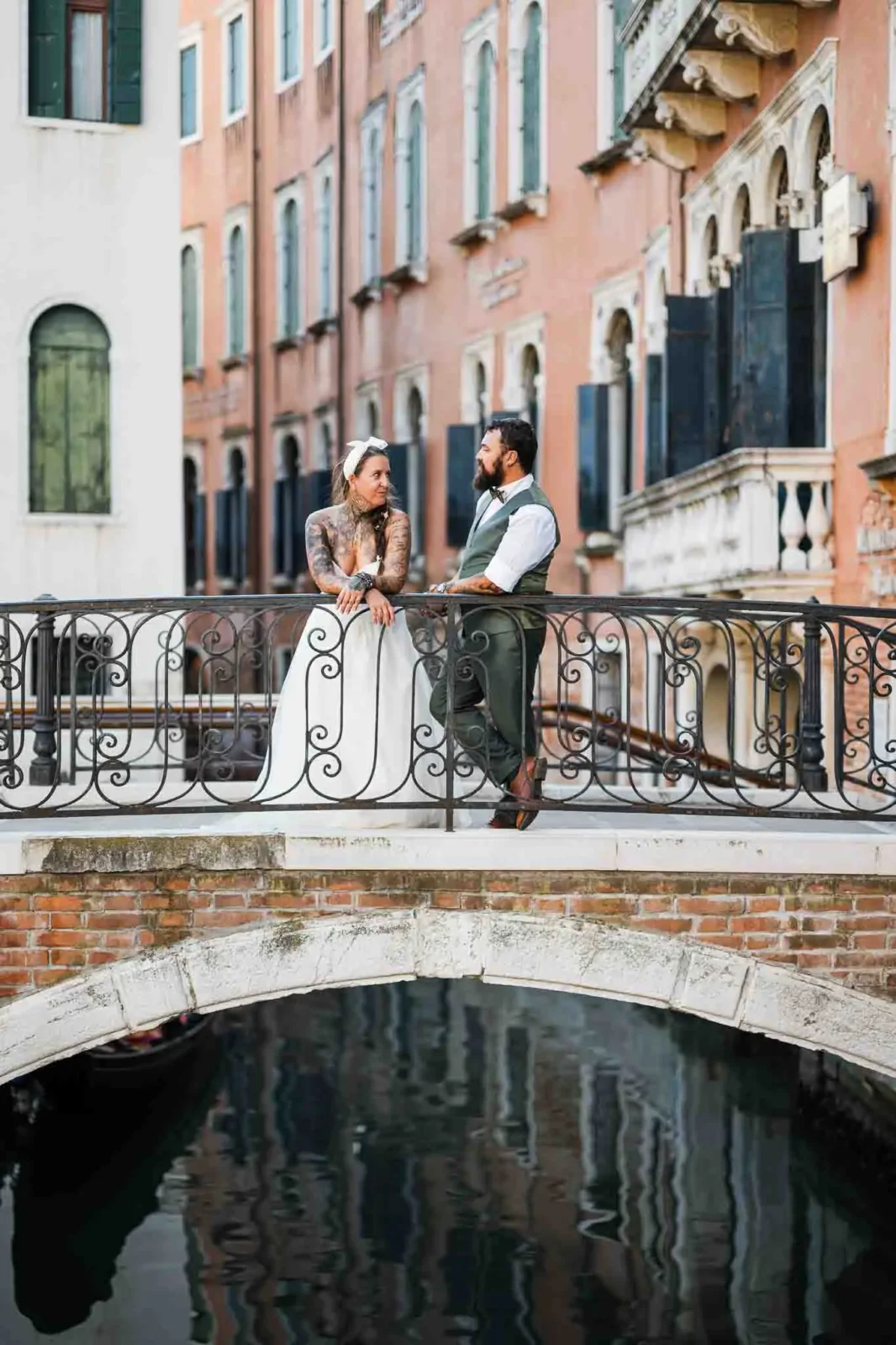 Elegant couple on a Venice canal bridge during their wedding photoshoot.