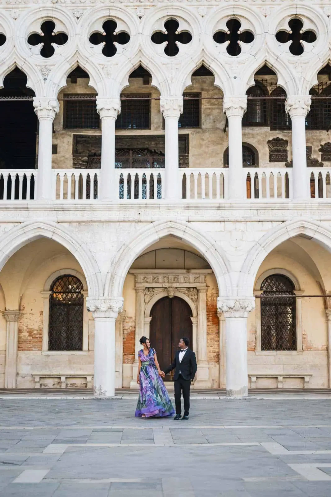 Elegant couple in formal attire at Venice historic architecture, engagement photoshoot.