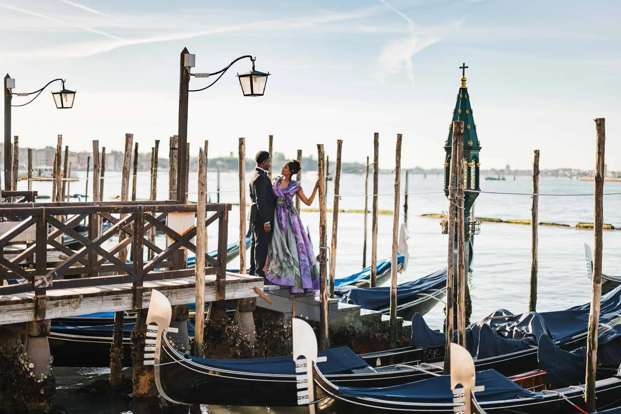 Elegant couple in Venice gondola harbor at sunset, romantic proposal scene.