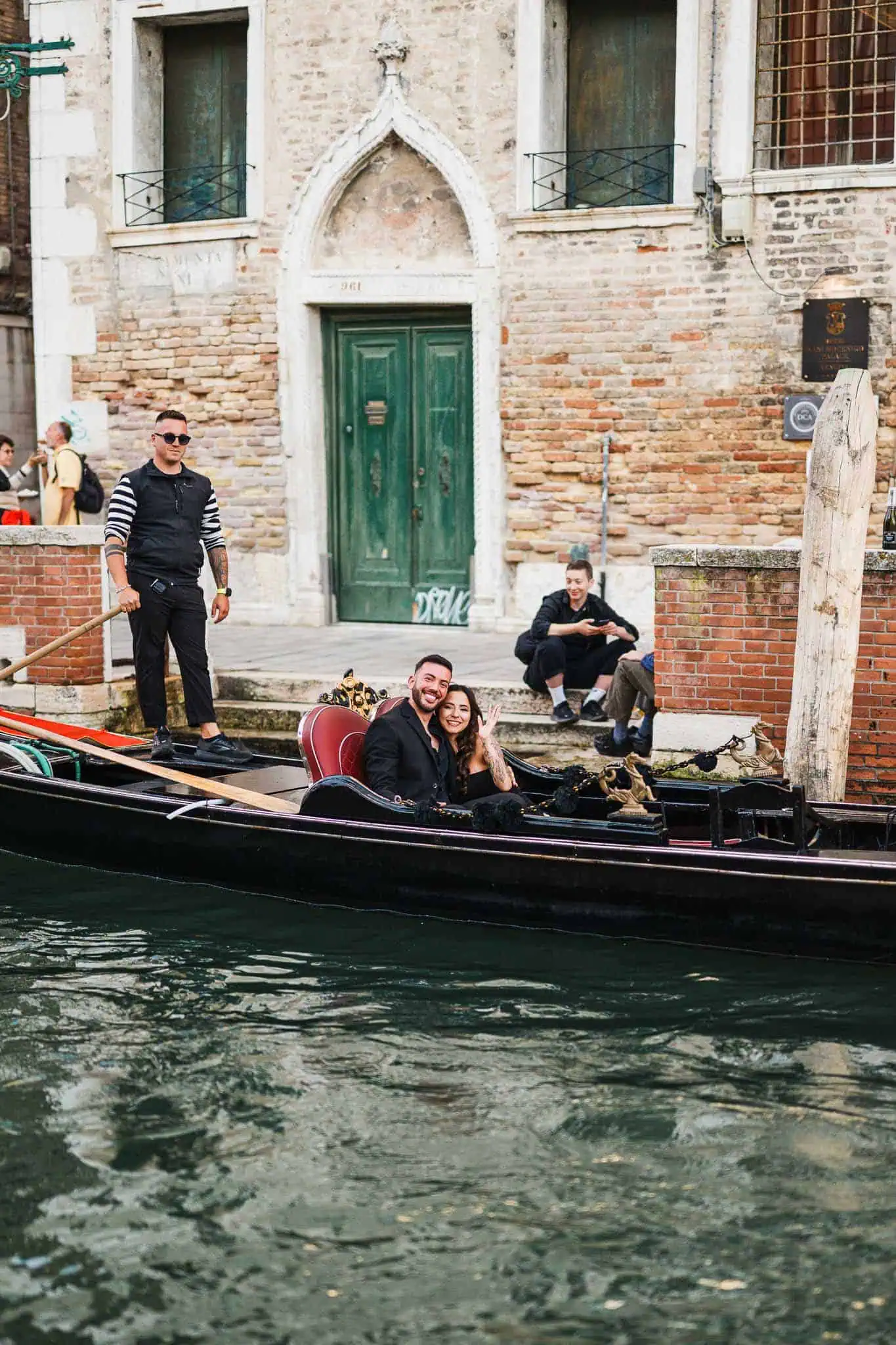 Gondola ride in Venice with joyful couple, historic buildings in the background, romantic engagement photography.