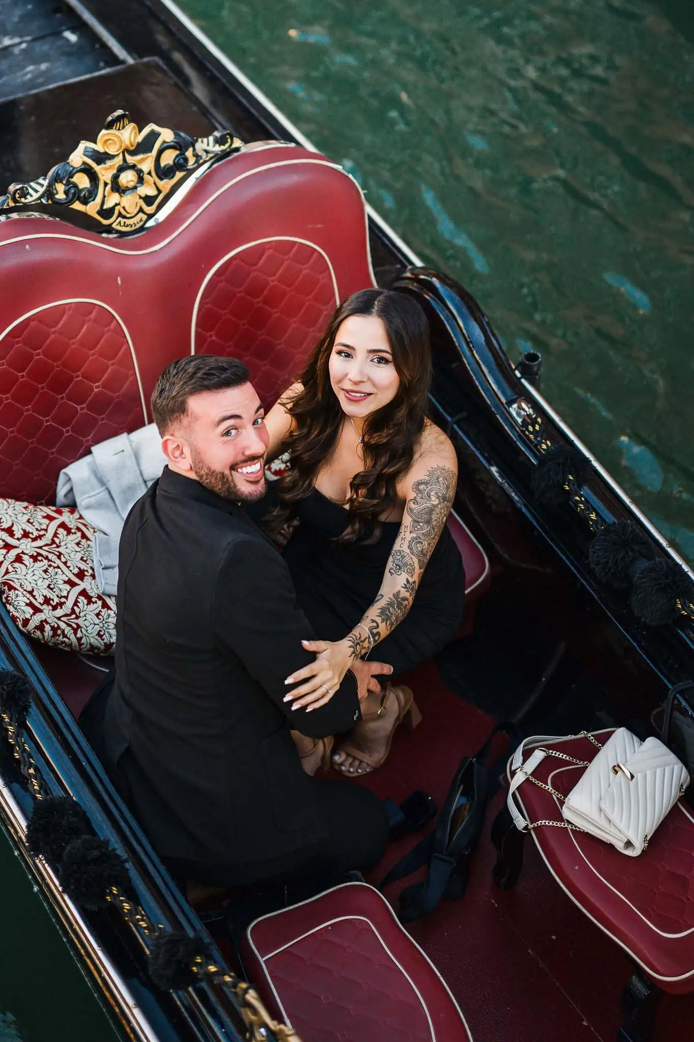 Romantic couple in a gondola in Venice, celebrating love and engagement.