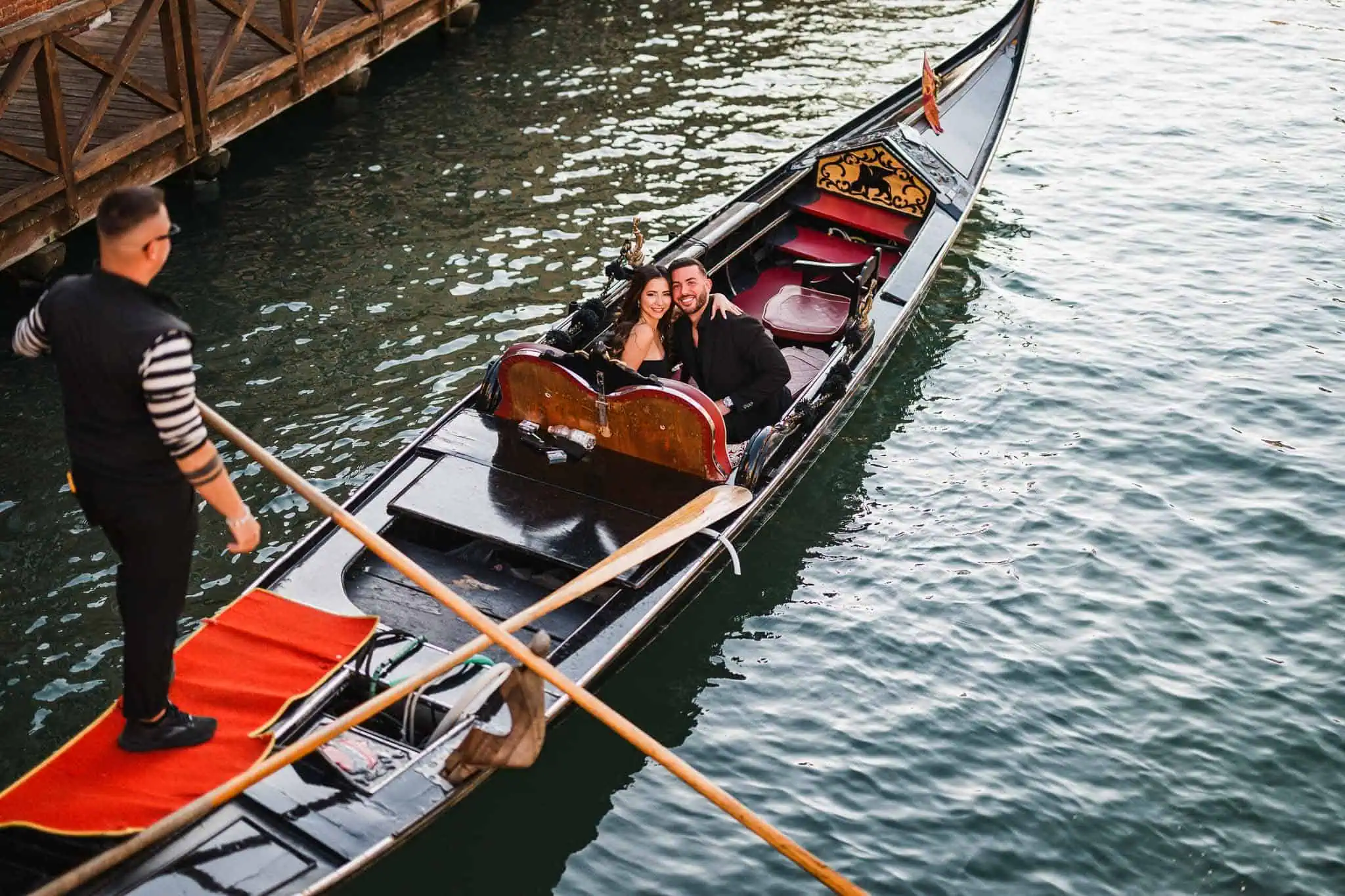 Romantic Venice gondola ride with couple and gondolier. Perfect for wedding, proposal, and engagement photoshoots.