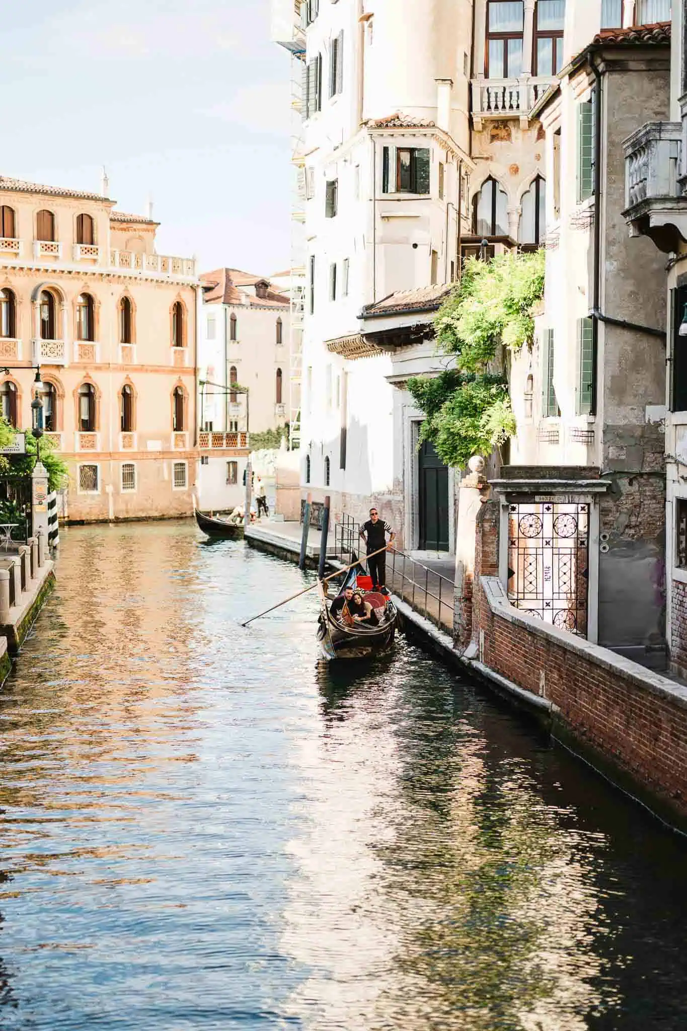 Gondola ride along Venice canal with historic buildings, perfect for romantic weddings or proposals.