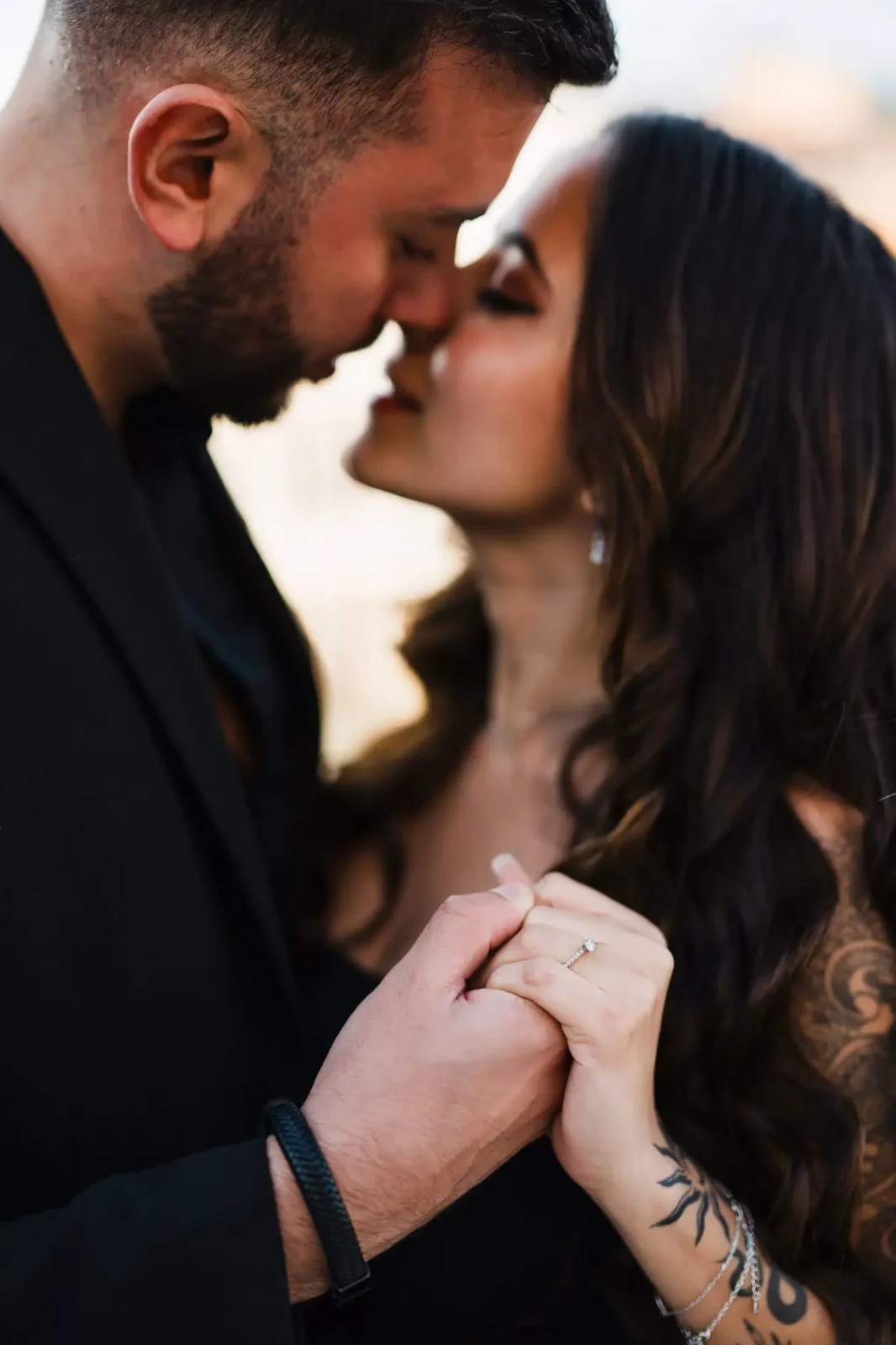 1. Close-up of romantic couple holding hands, engaged in a tender moment.