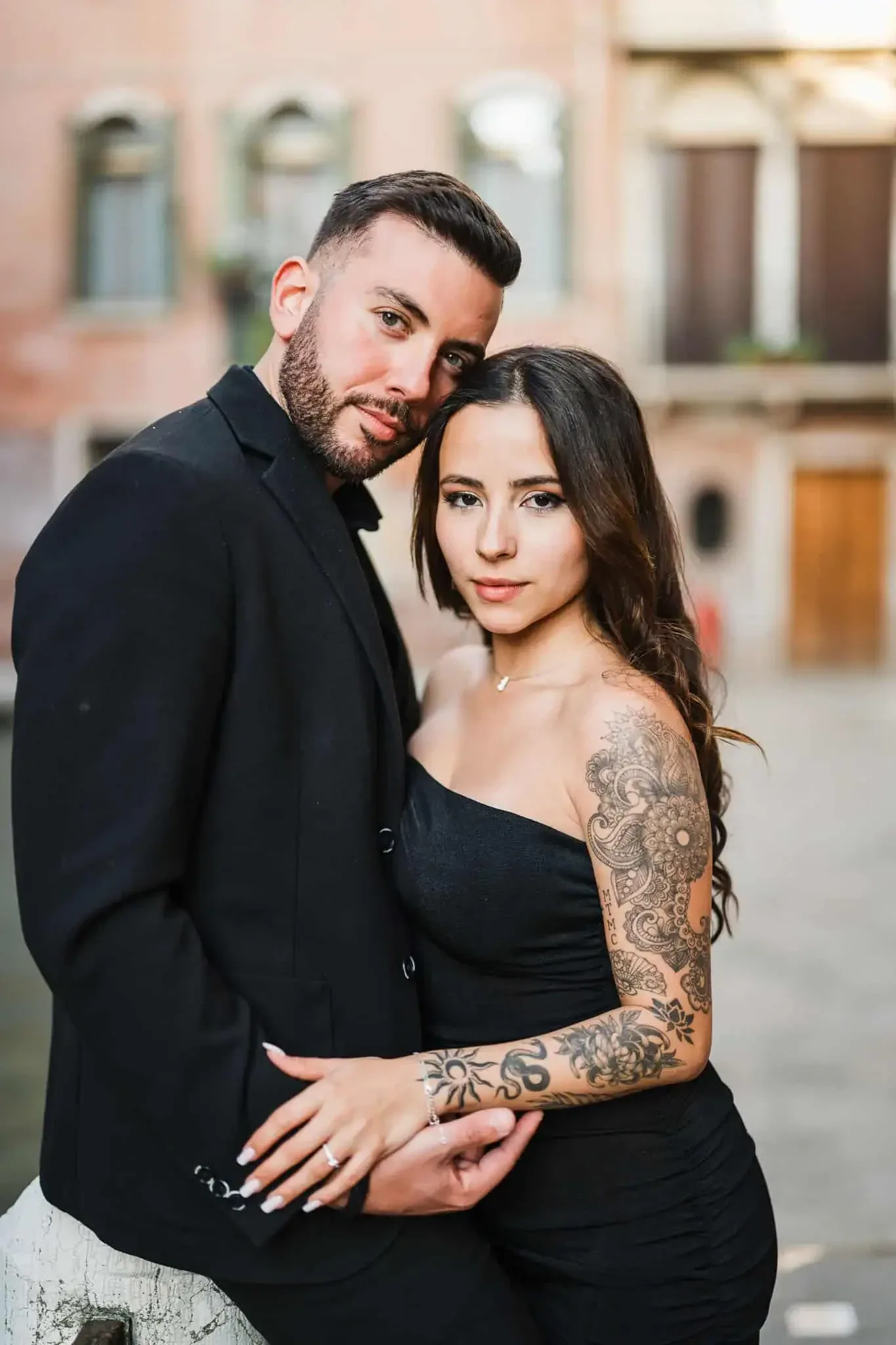 Bride and groom posing close together in Venice, romantic engagement photography in front of historic buildings.