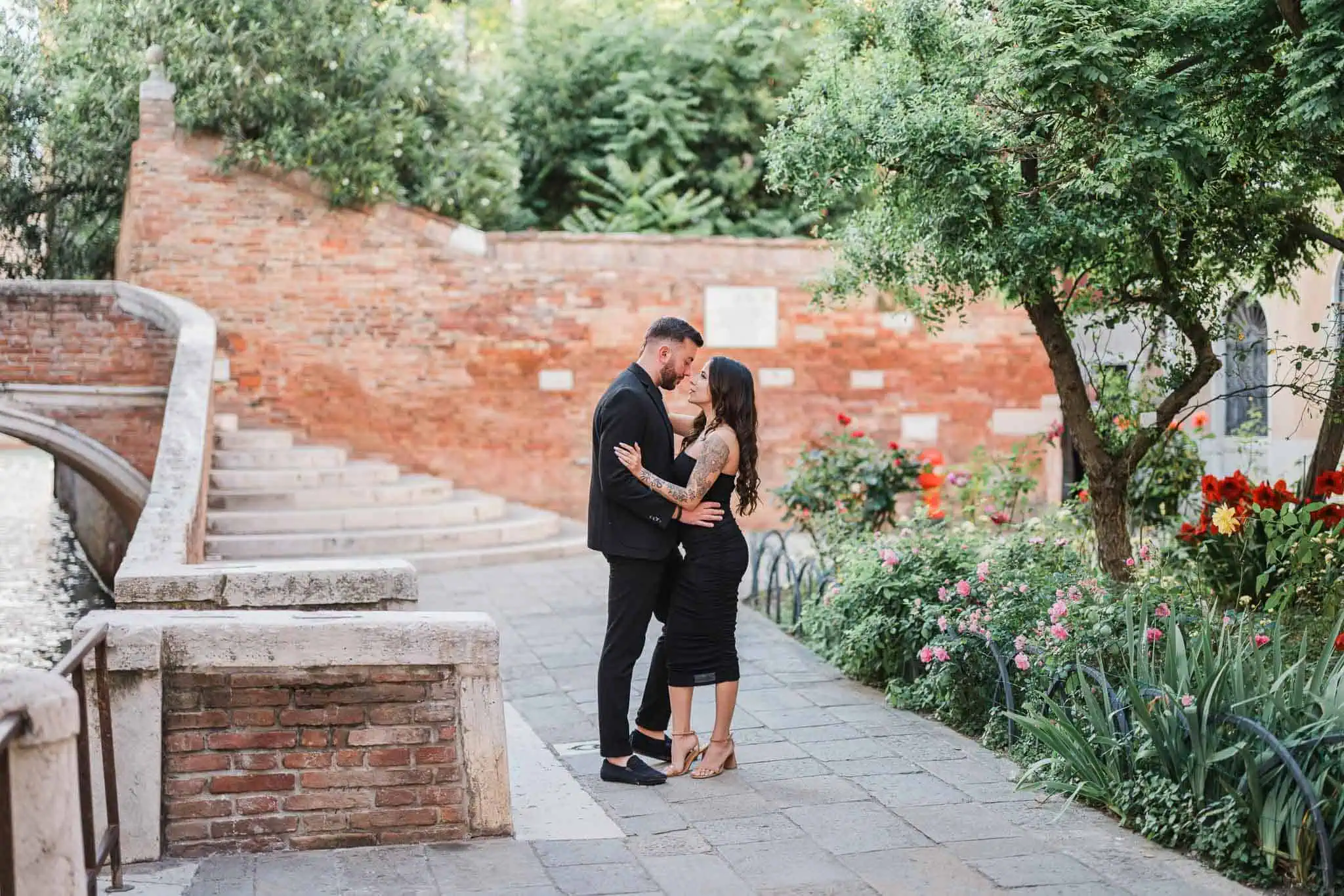 1. Romantic couple in Venice with lush garden and historic brick wall background.