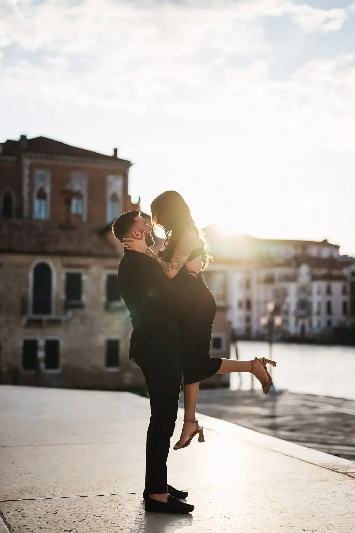 Loving couple in a romantic embrace during sunset in Venice, perfect for engagement and proposal photos.
