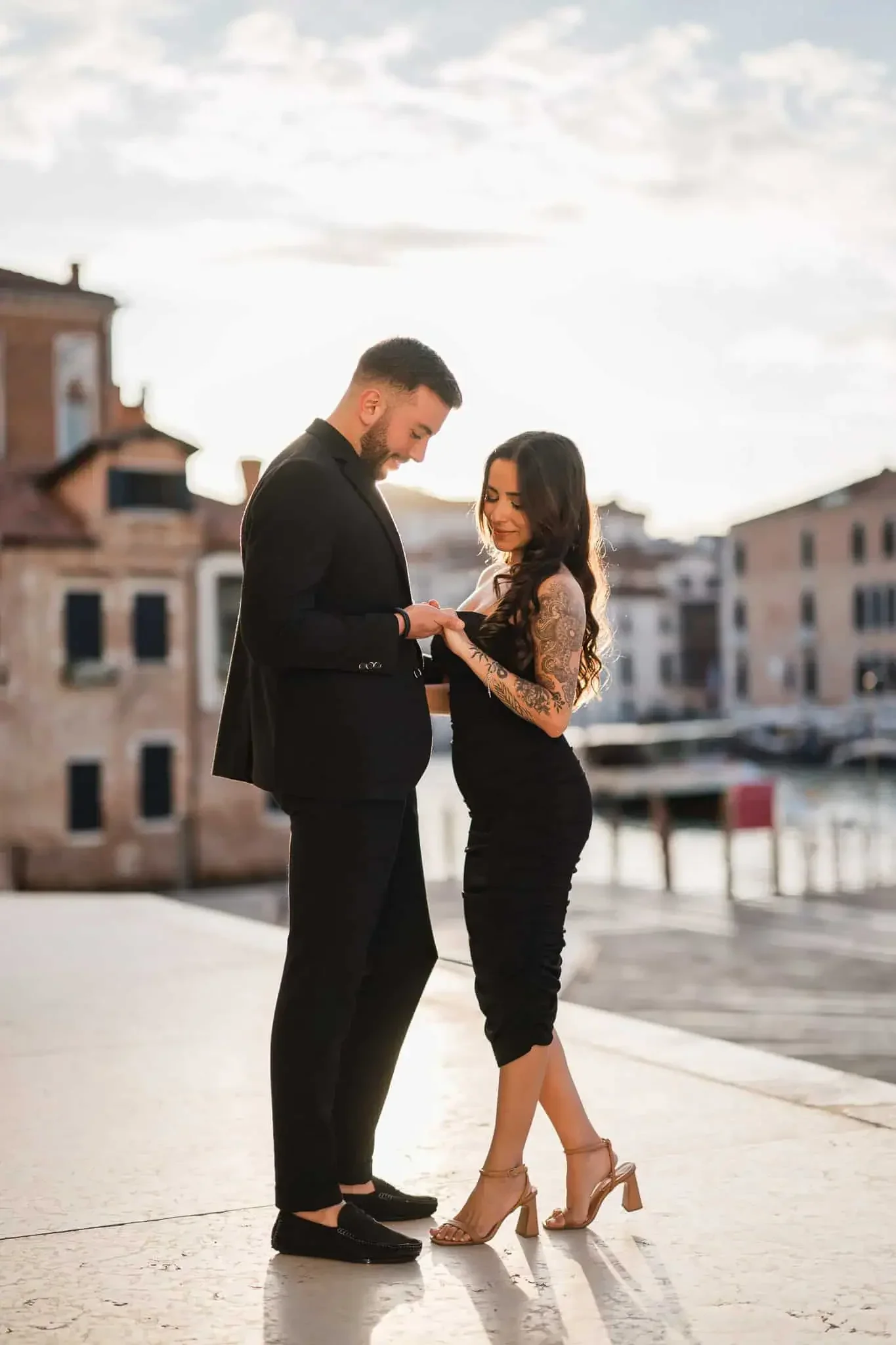 Romantic Venice engagement photoshoot with couple by canal during sunset.