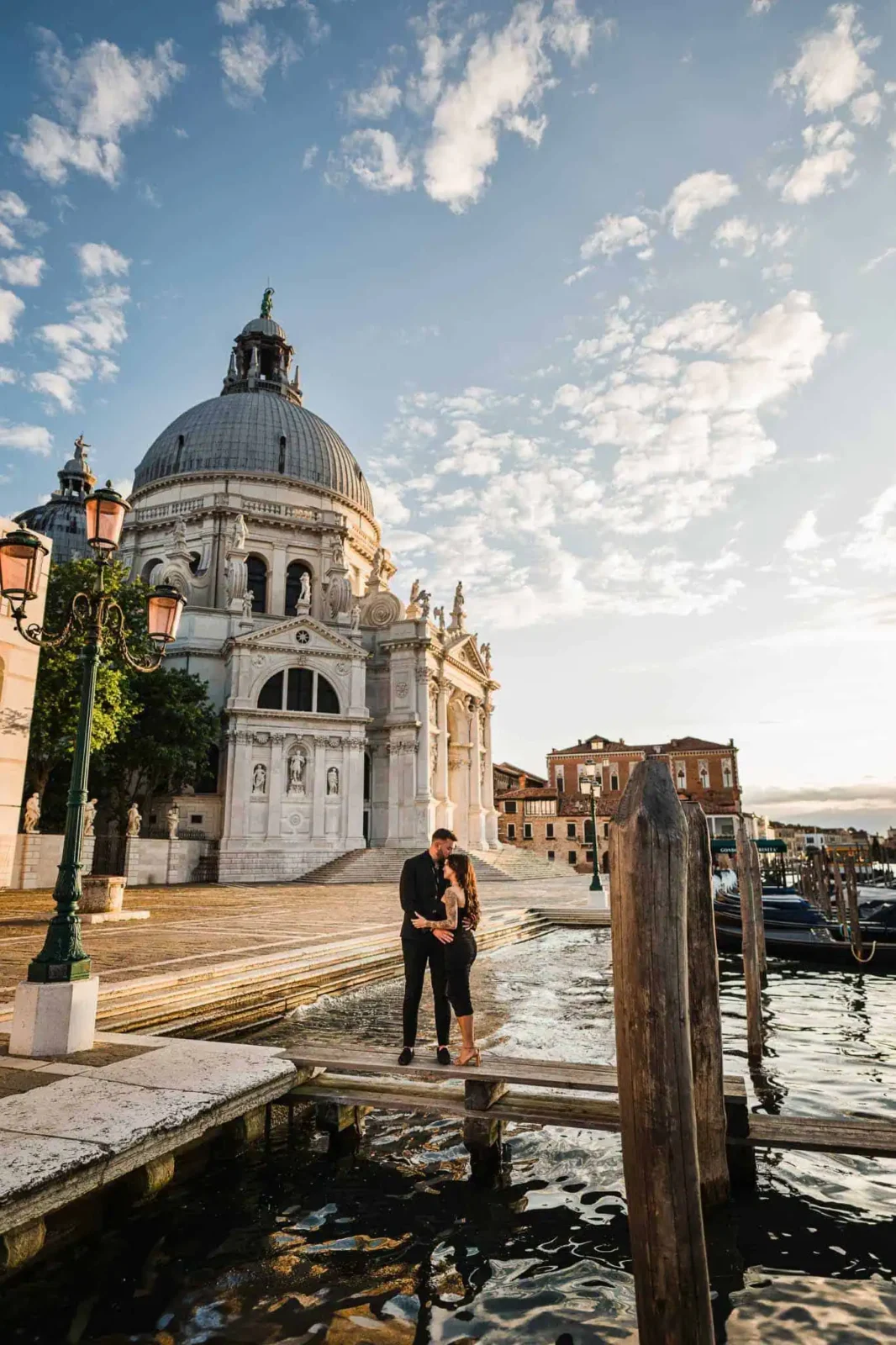 A romantic couple in Venice with St. Paul’s Cathedral in the background at sunset.
