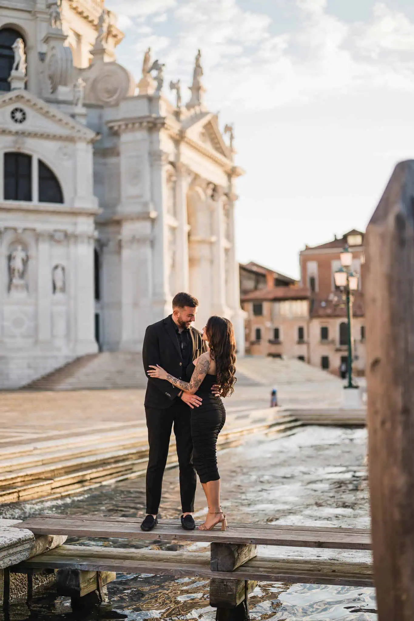 Romantic couple in elegant attire sharing a moment by the canals in Venice, perfect for engagements.