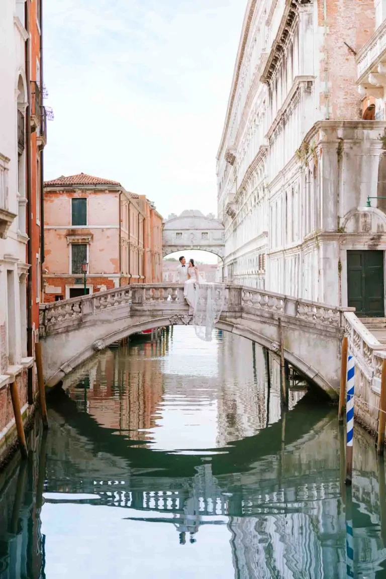 1. Romantic Venice wedding couple on Rialto Bridge with historic architecture and canal reflections.