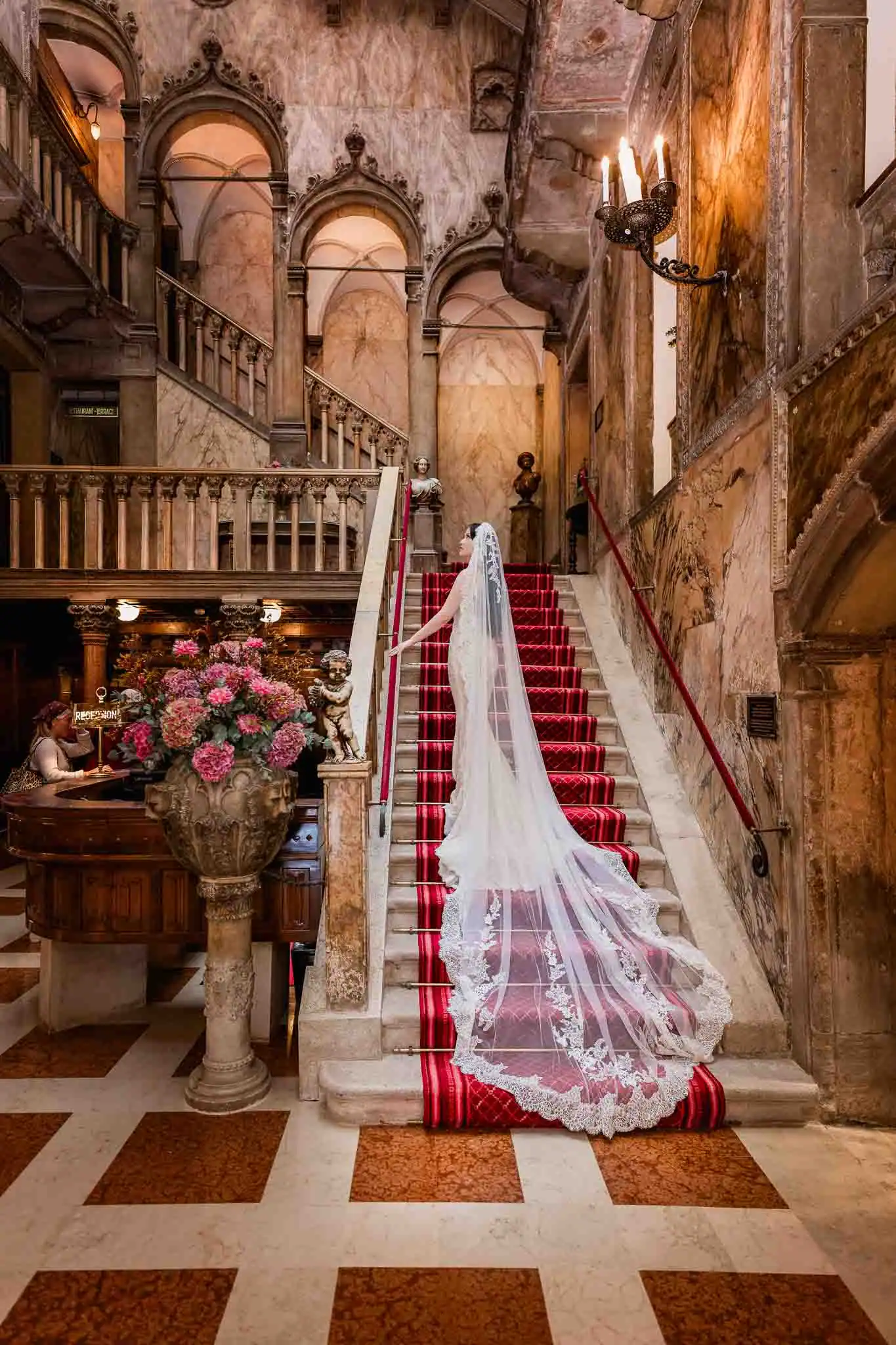 Elegant bride ascending marble staircase in historic Venice hotel, capturing timeless wedding moments.