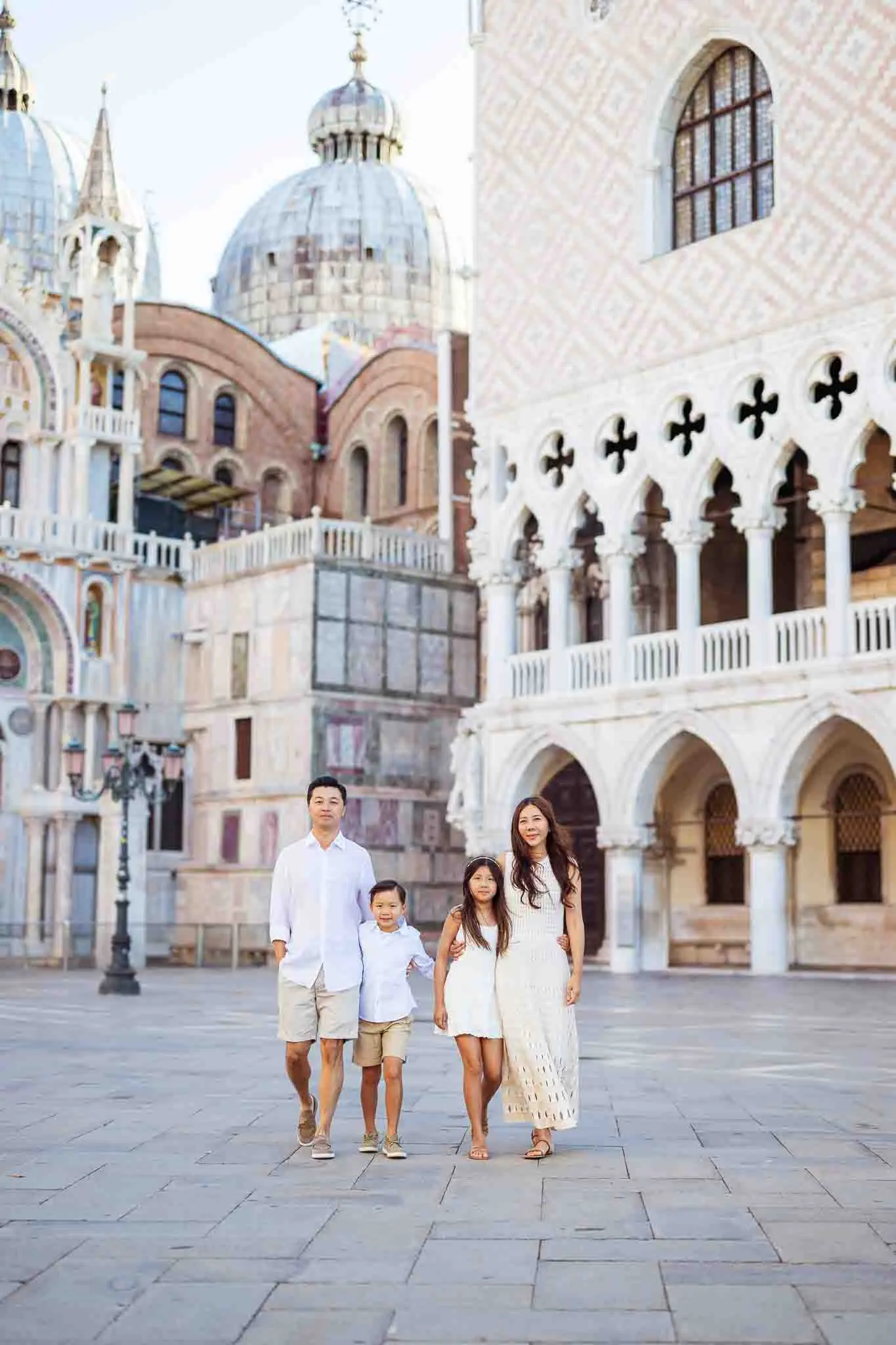 1. Family walking in Venice, Italy with historic architecture backdrop.