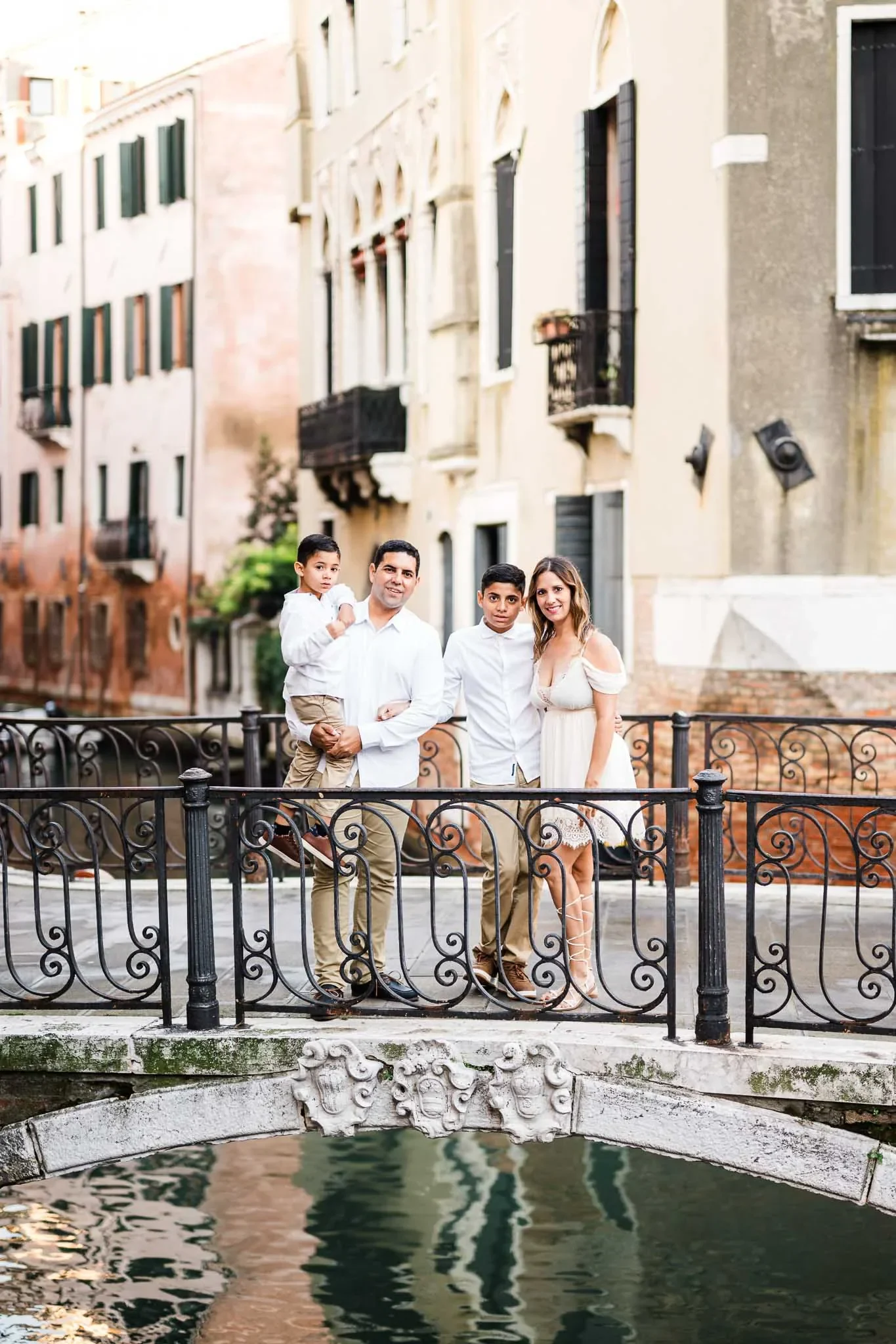 Beautiful family portrait on a Venice canal bridge, capturing authentic moments in Italy’s romantic city.