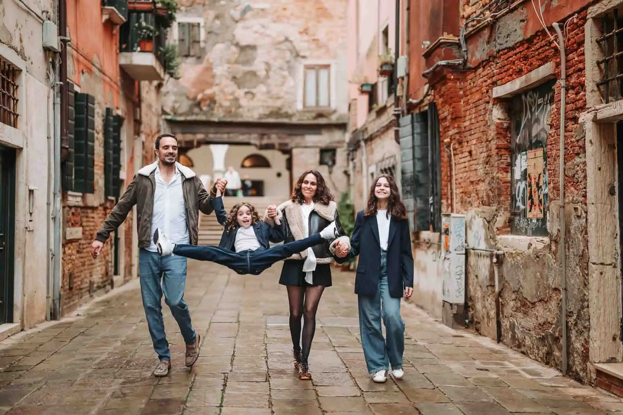 Vibrant family walking through Venice alley, capturing joyful moments in the historic city.