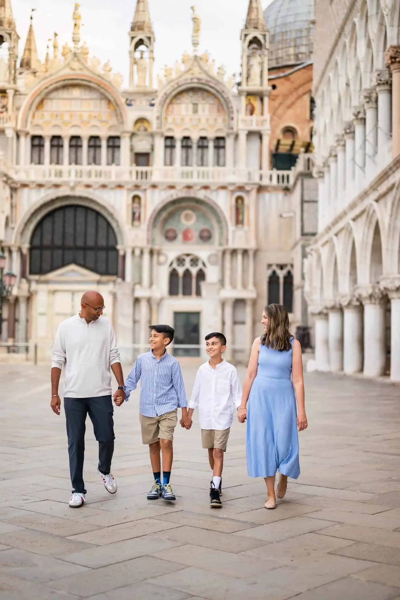 1. Diverse family walking hand-in-hand in Venice's historic Piazza, capturing joyful moments.