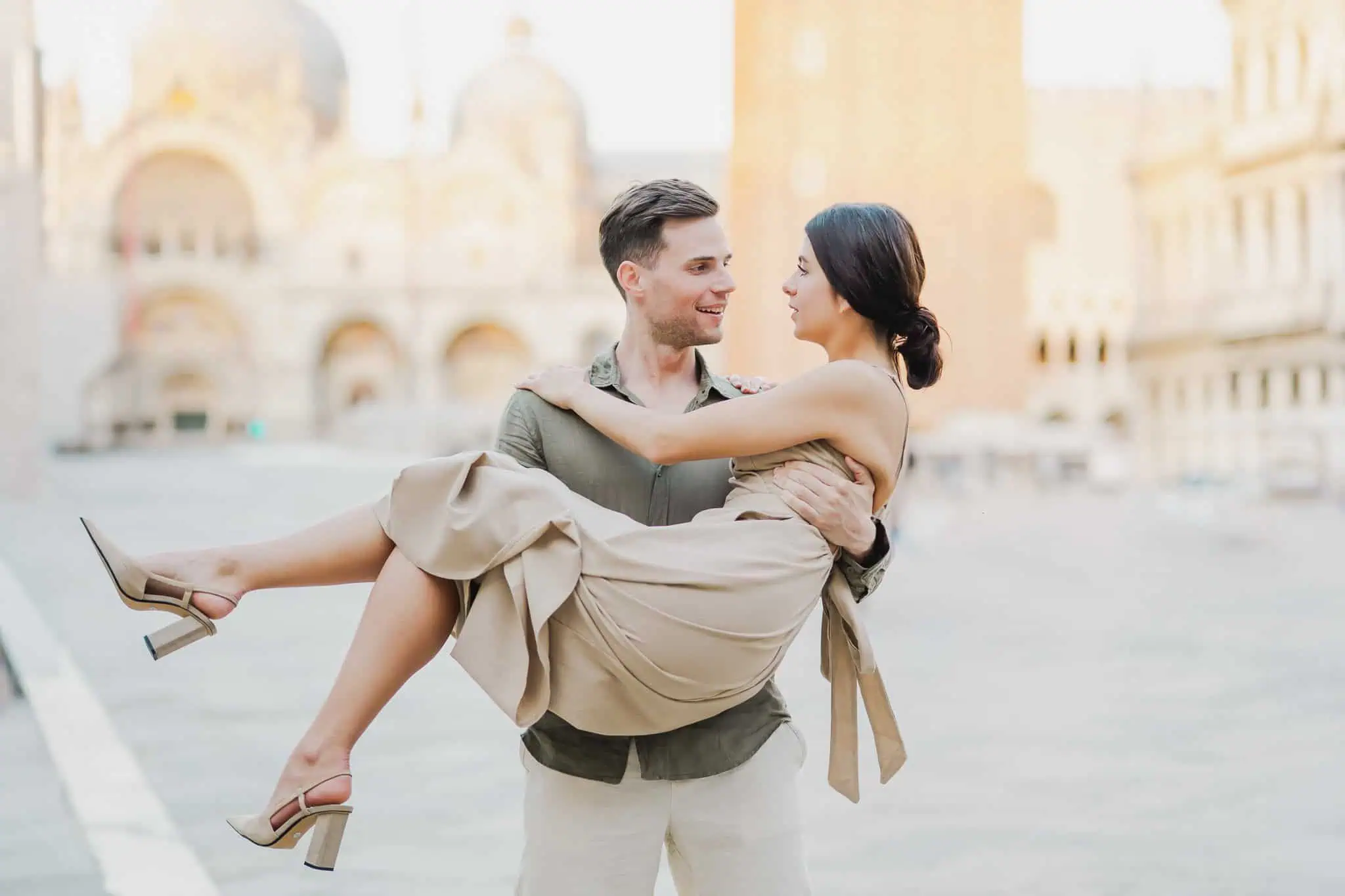 1. Romantic couple in Venice, Italy, dressed stylishly, embracing for wedding or engagement photos.