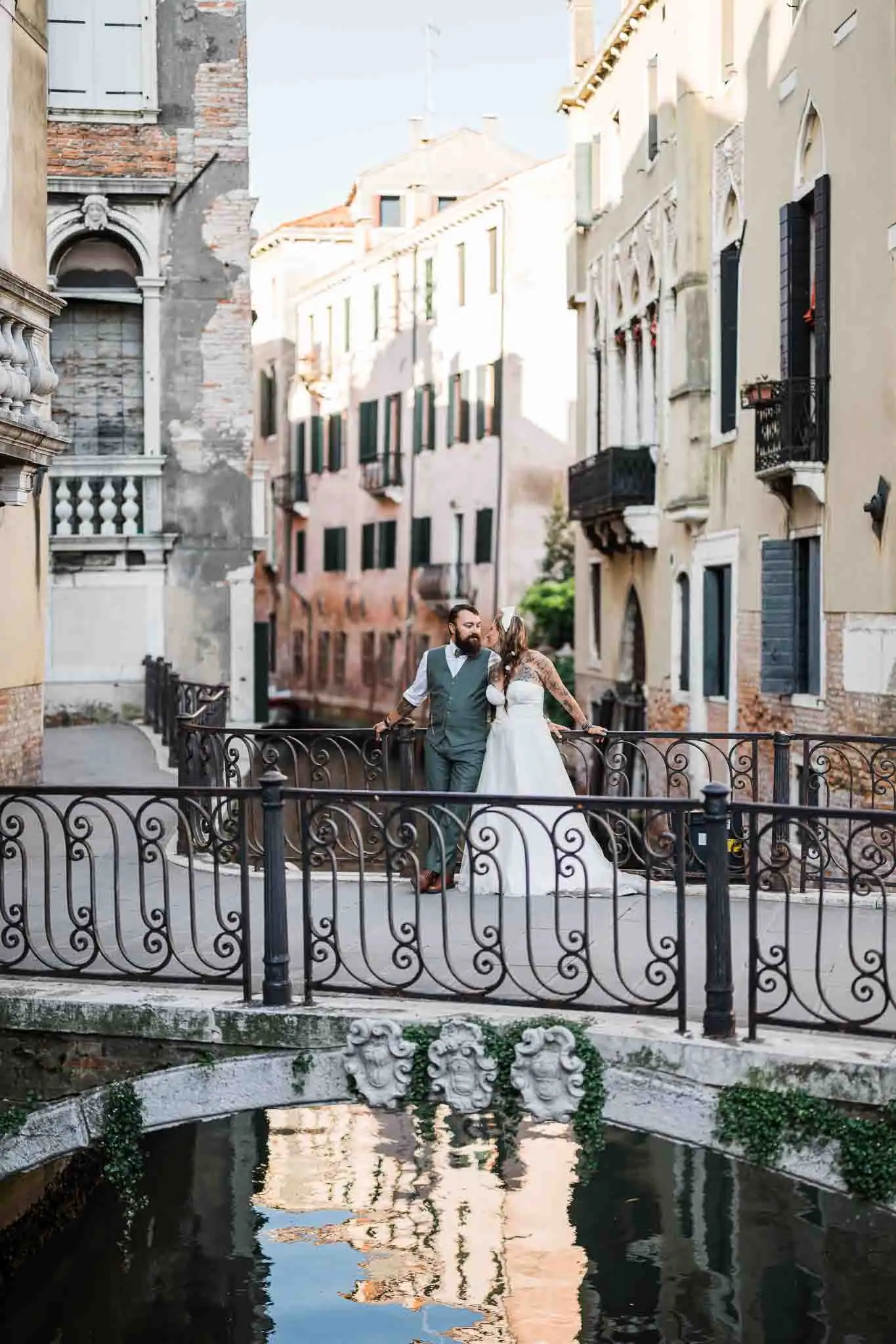 1. Romantic couple portrait on Venice canal bridge with historic buildings backdrop.