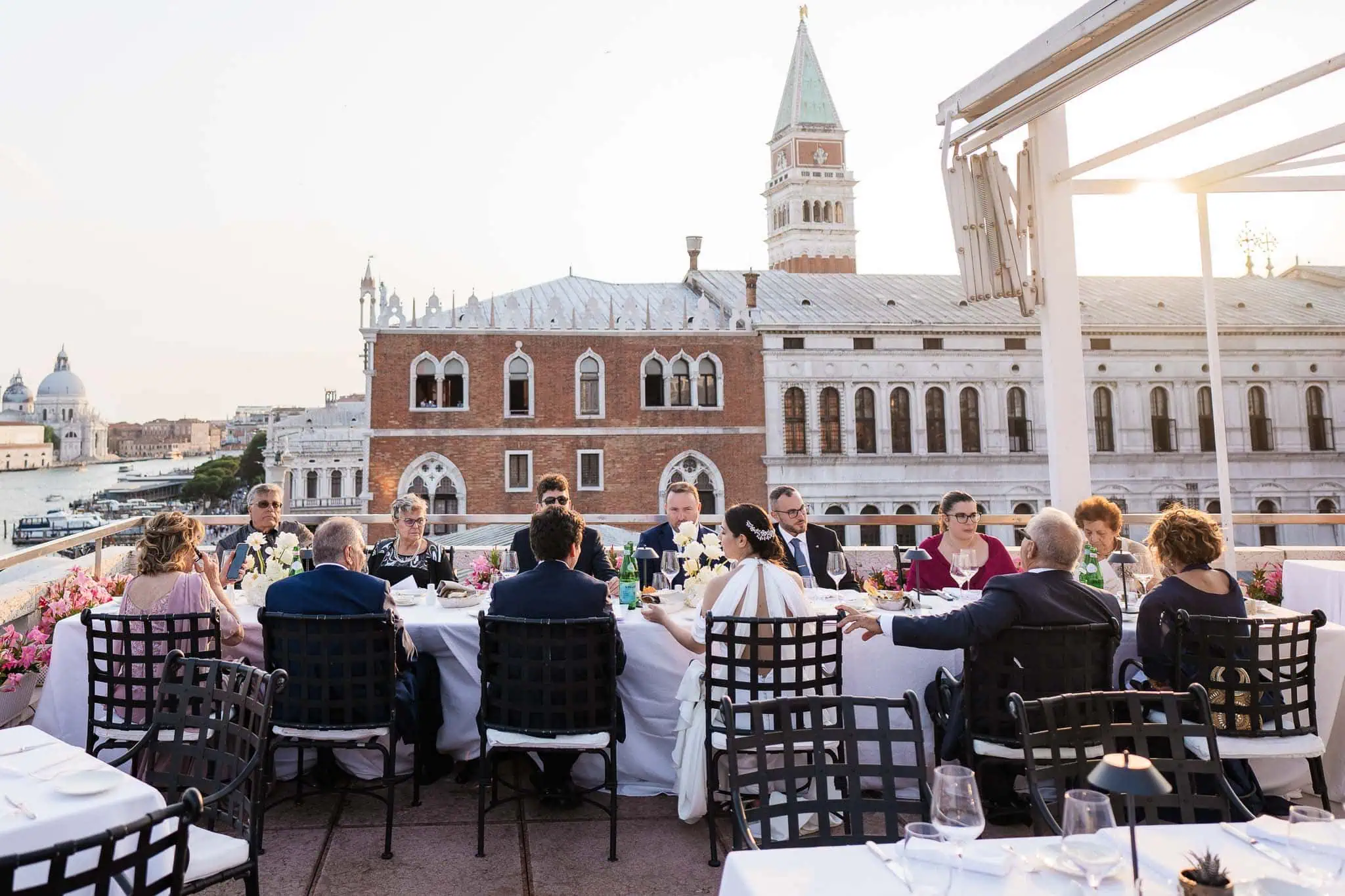 Elegant Venice rooftop wedding reception with historic architecture in the background.