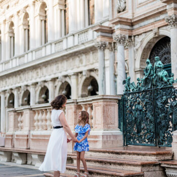 San Marco square in Venice, family walking with child smiling, parents holding hands, child looking at camera, during lat.