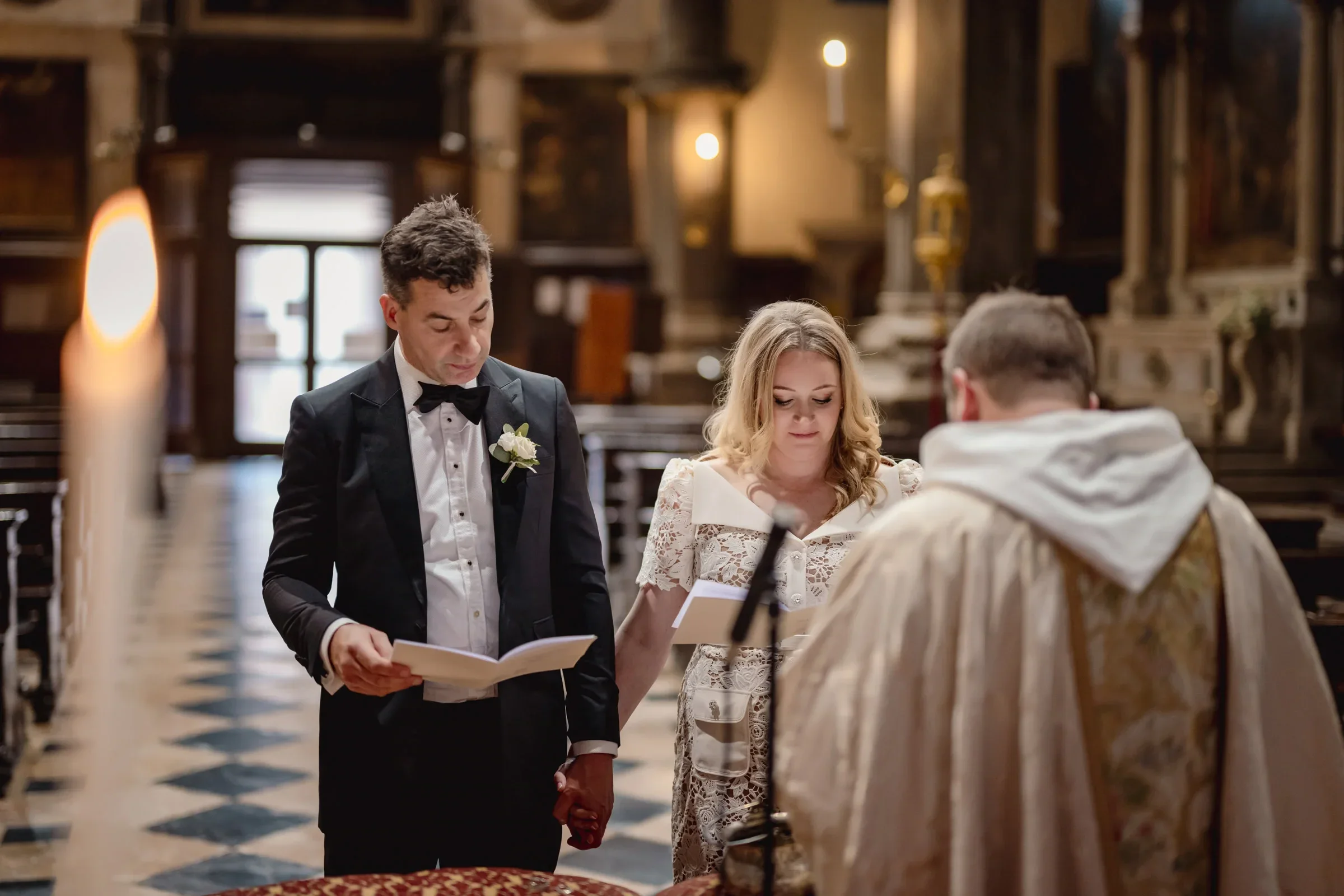 Young couple exchanging vows during intimate wedding ceremony inside a historic church.