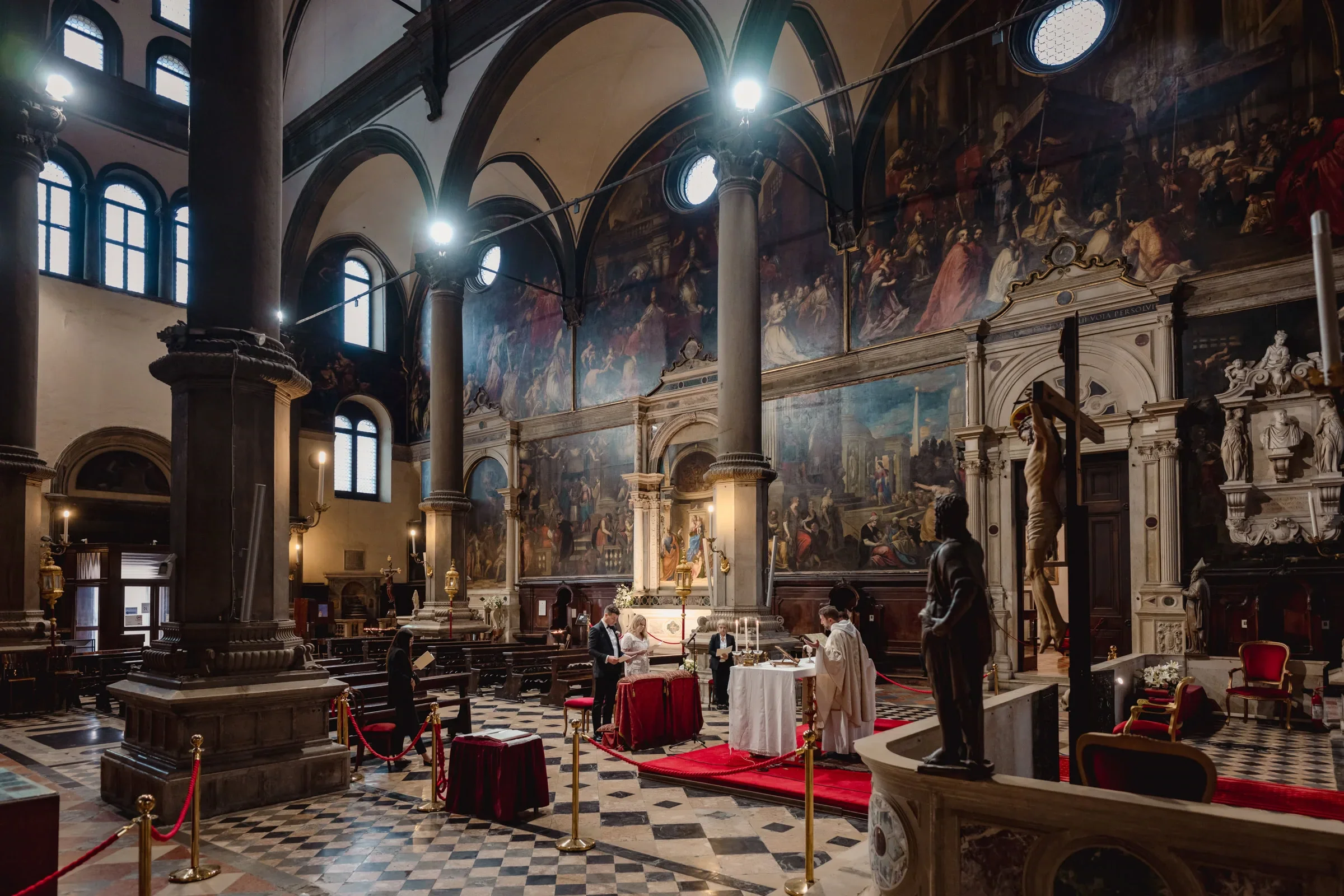 1. Elegant couple ceremony inside historic church with dramatic murals and towering columns.