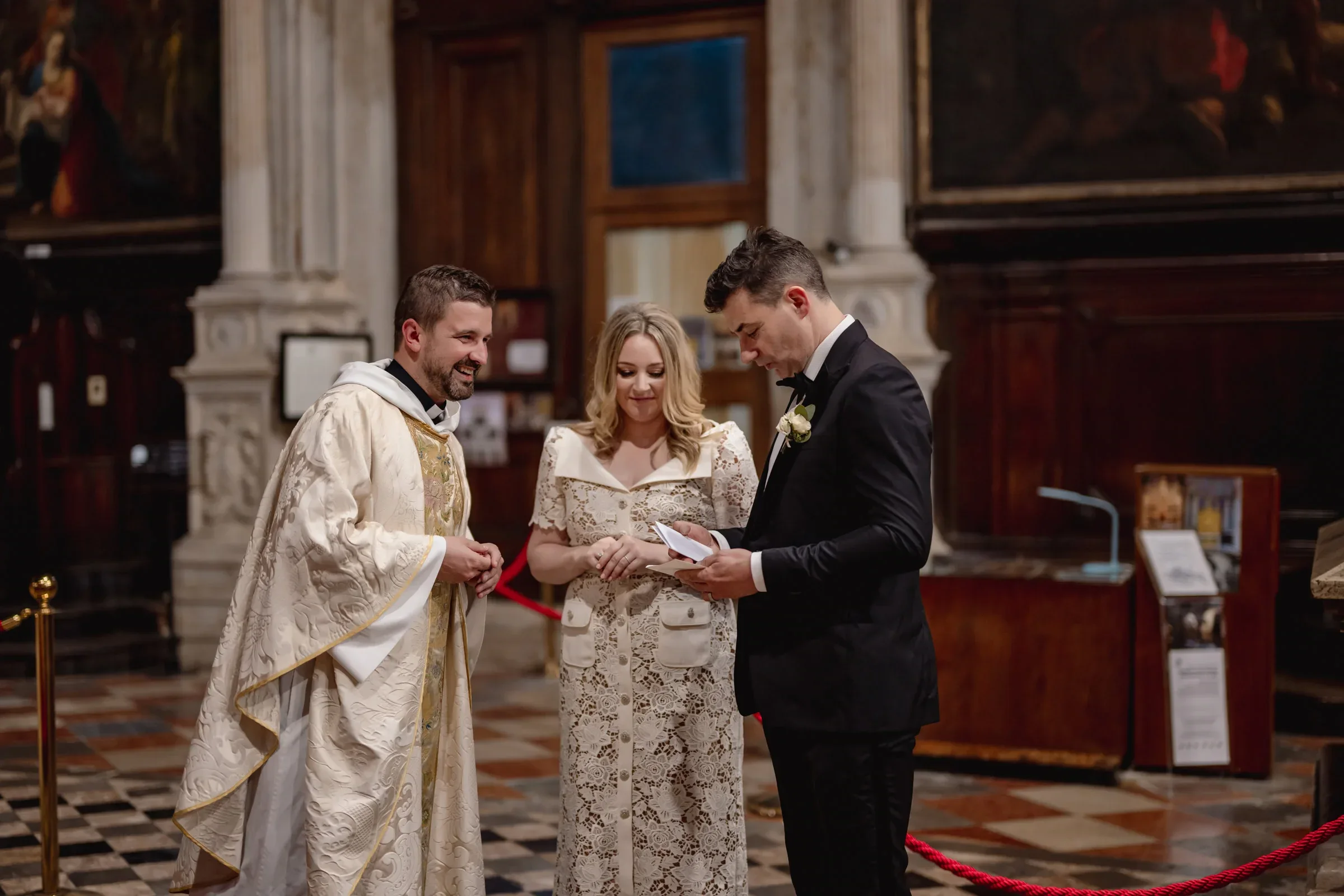Elegant couple ceremony during an elopement in a historic church with a priest and officiant.