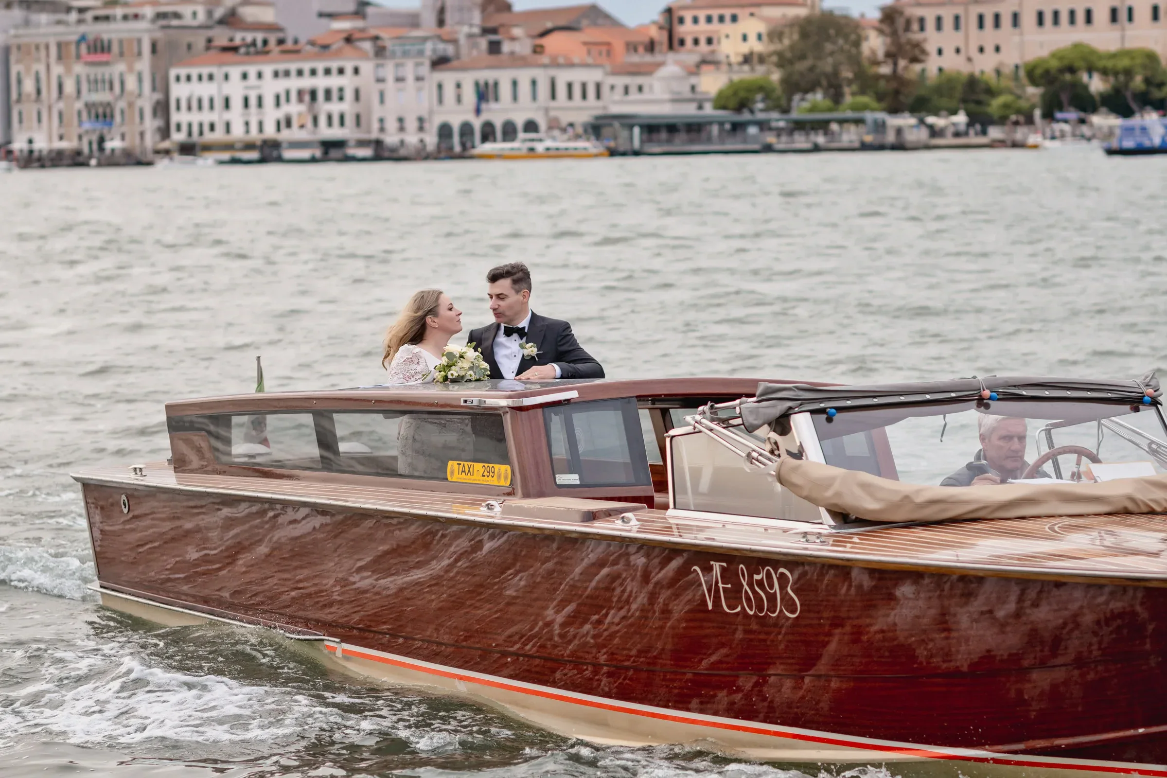 Elegant couple on a wooden boat during an intimate ceremony on the water.