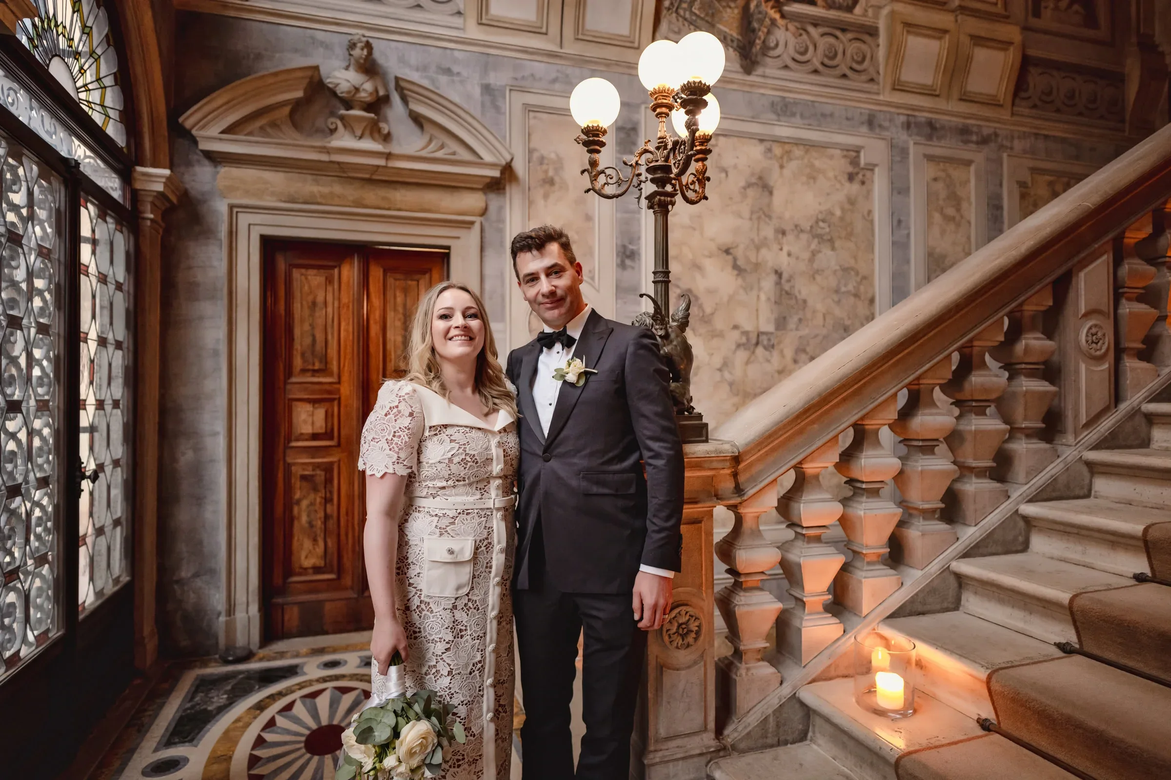 Elegant couple in vintage attire inside ornate historic building for intimate elopement ceremony.