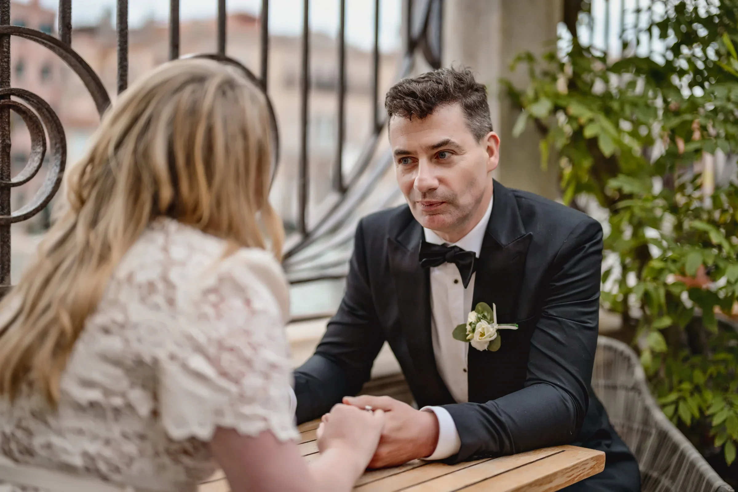 Elegant couple exchanging vows on a cozy outdoor terrace, capturing an intimate elopement moment.