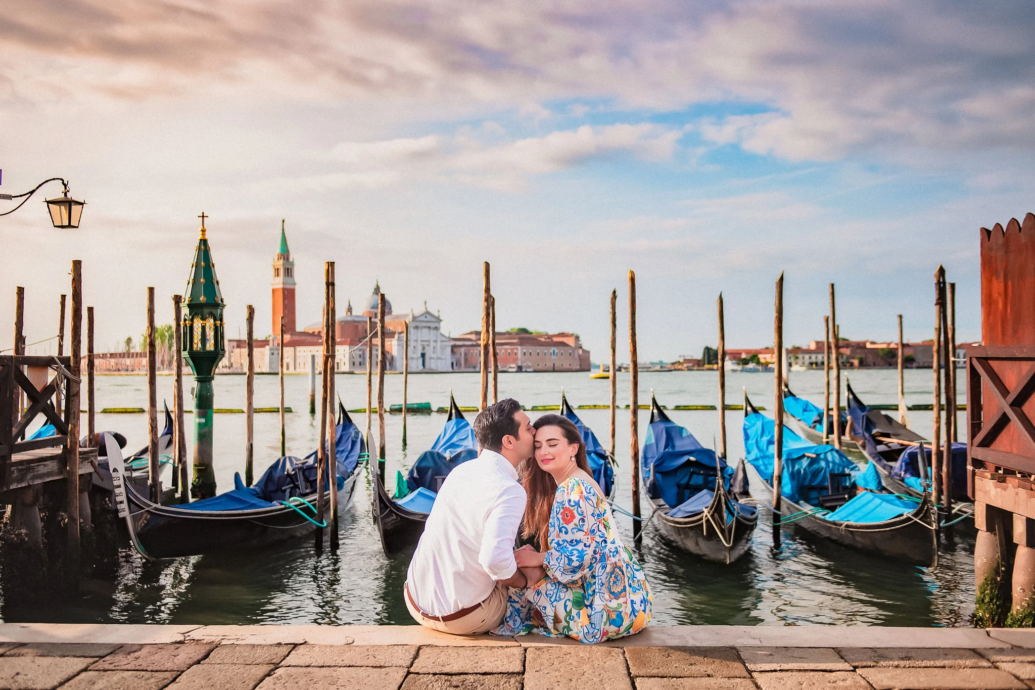 Romantic Venice engagement photoshoot with couple by gondolas and scenic city views.