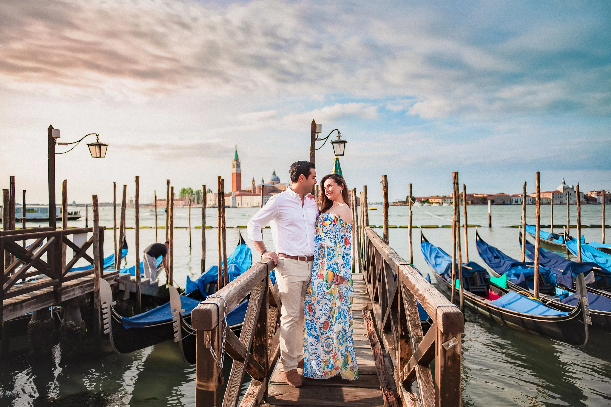 1. Romantic Venice couple photoshoot at gondola dock with city skyline.