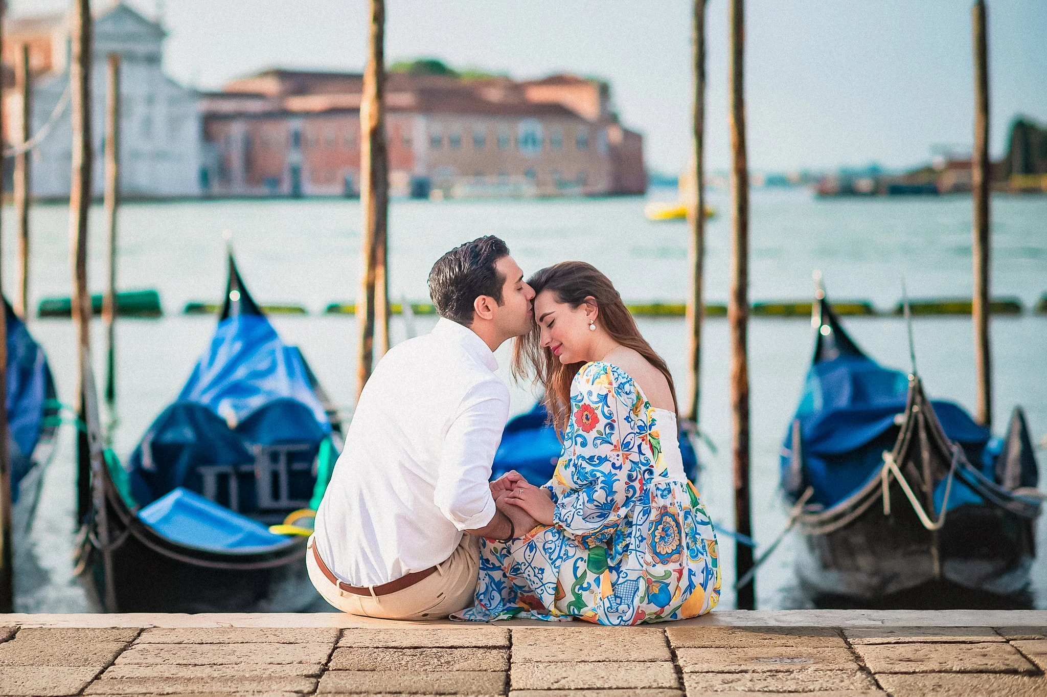Elegant couple sharing a romantic moment by the Venice waterfront, perfect for wedding, proposal, and engagement photos.