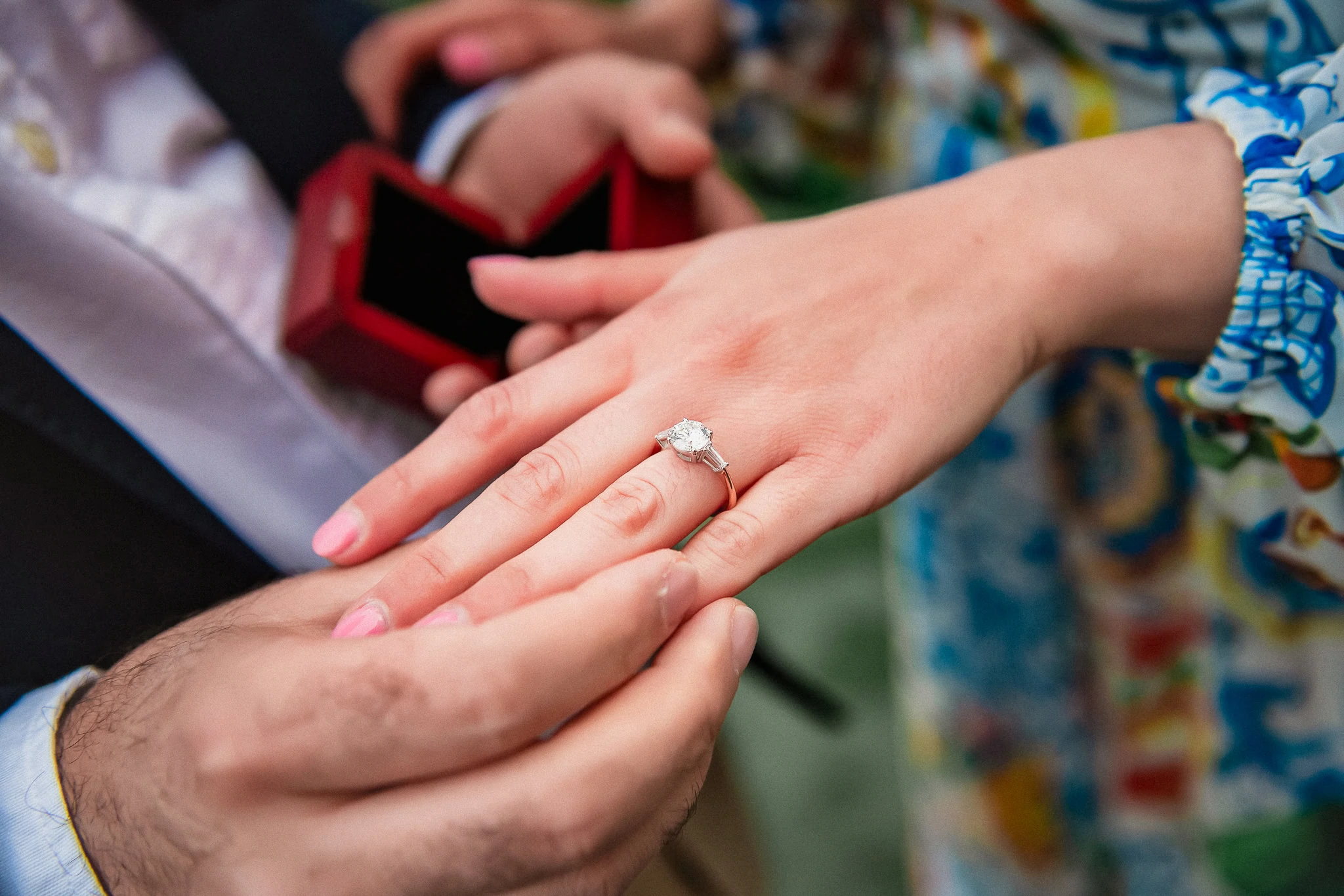 Elegant engagement ring on a woman's finger in Venice wedding scene.