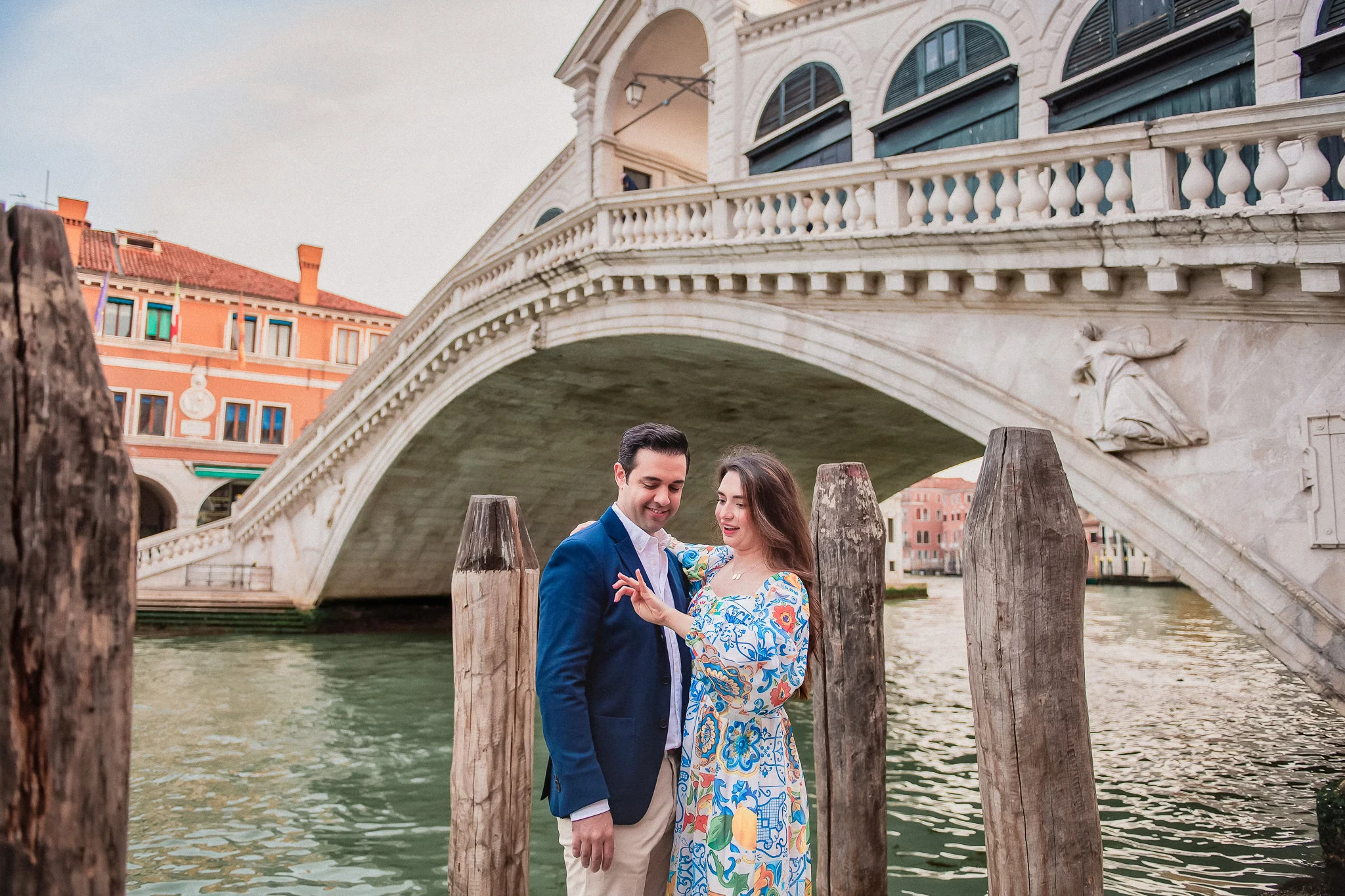 Romantic Venice couple during engagement photoshoot by historic bridge, Italy.