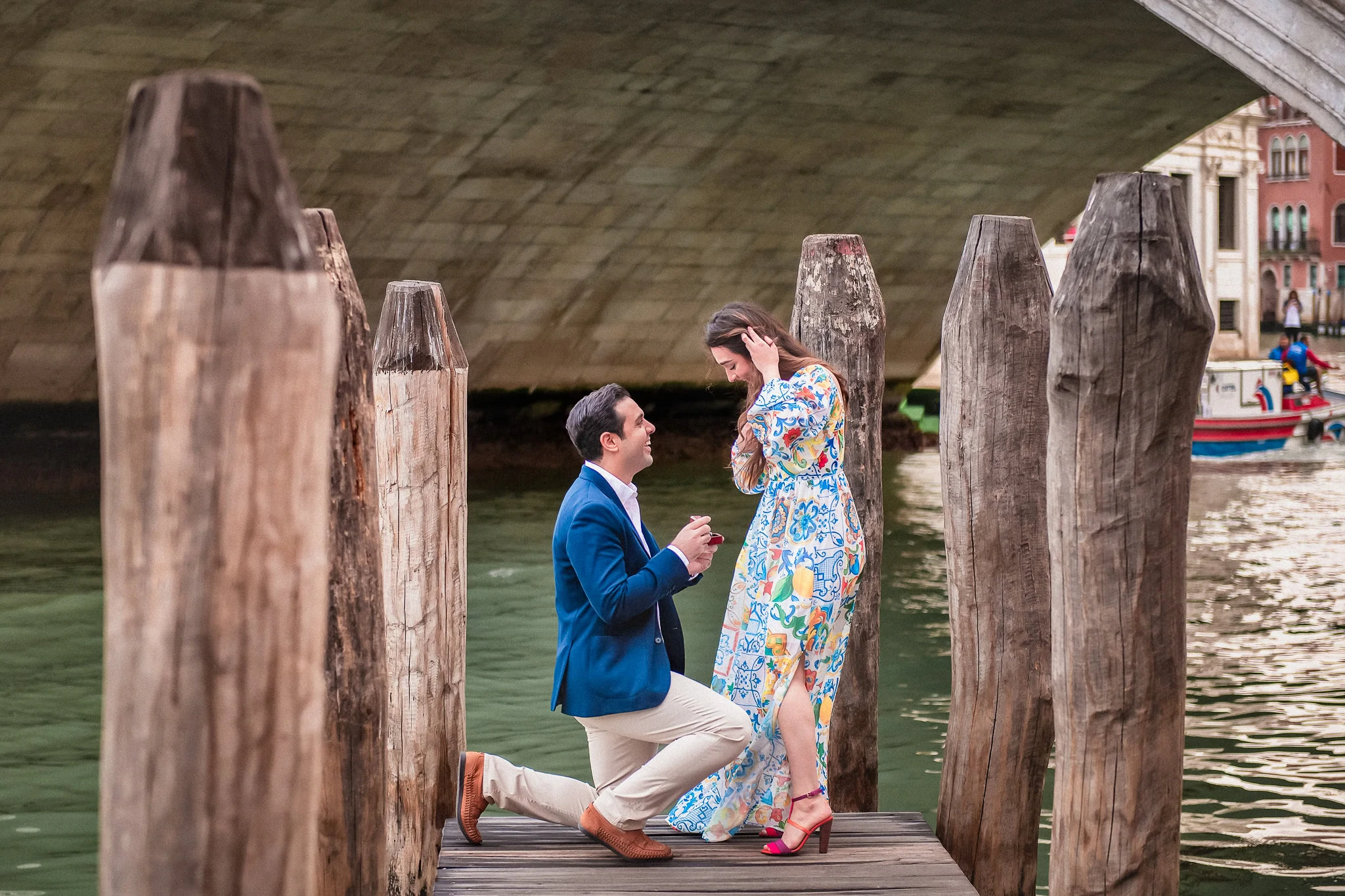 Romantic proposal on Venice dock with gondola background, engagement photography in Italy.