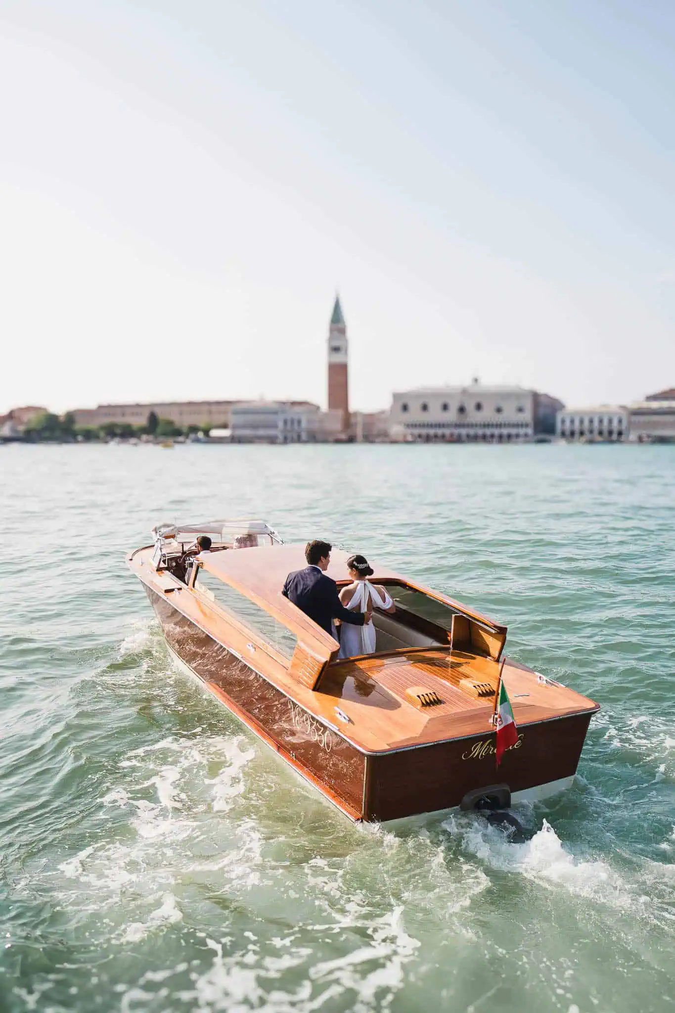 Luxury wooden boat with romantic couple in Venice, Italy.
