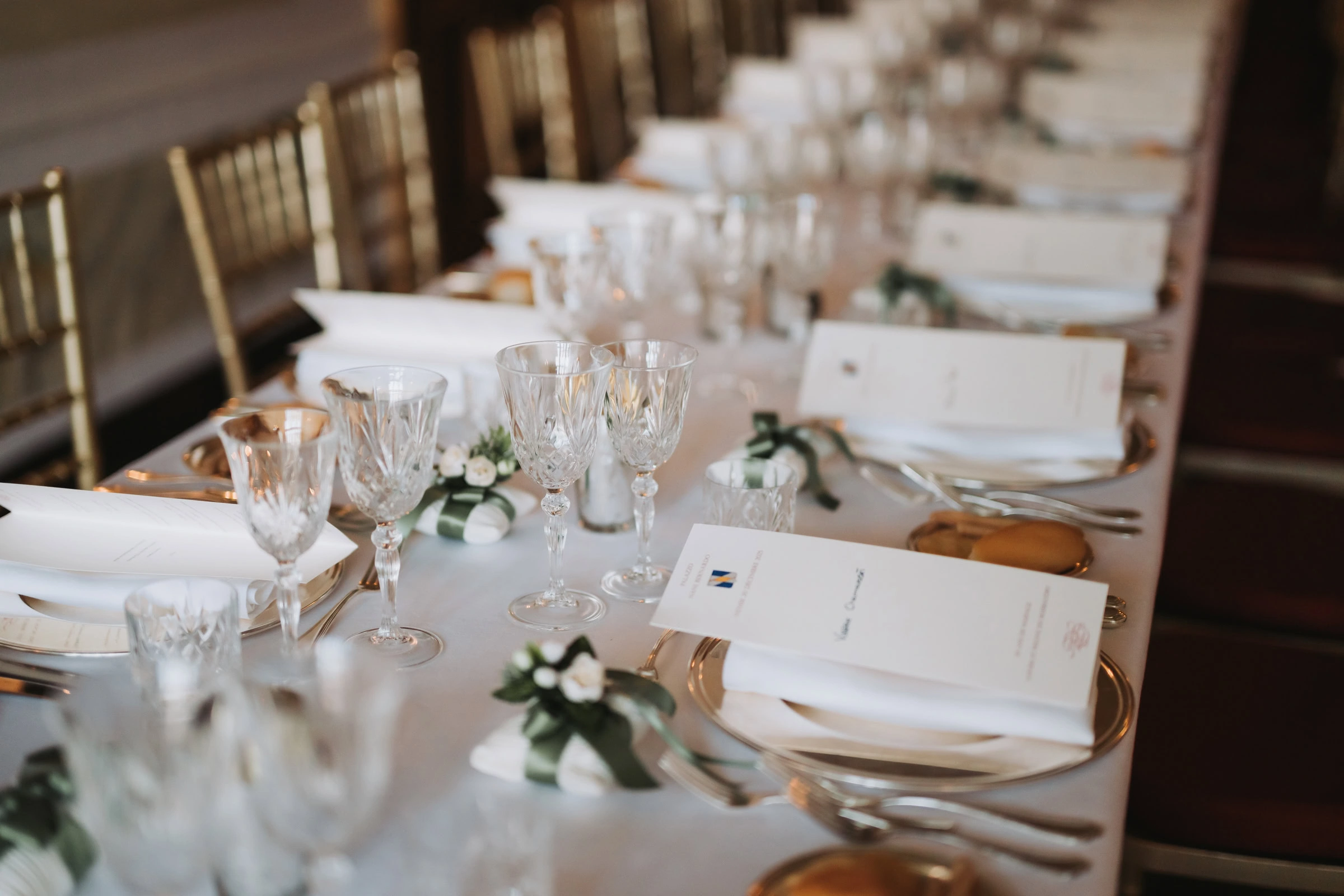 Elegant wedding table setting with crystal glasses, white napkins, and floral accents in Venice.