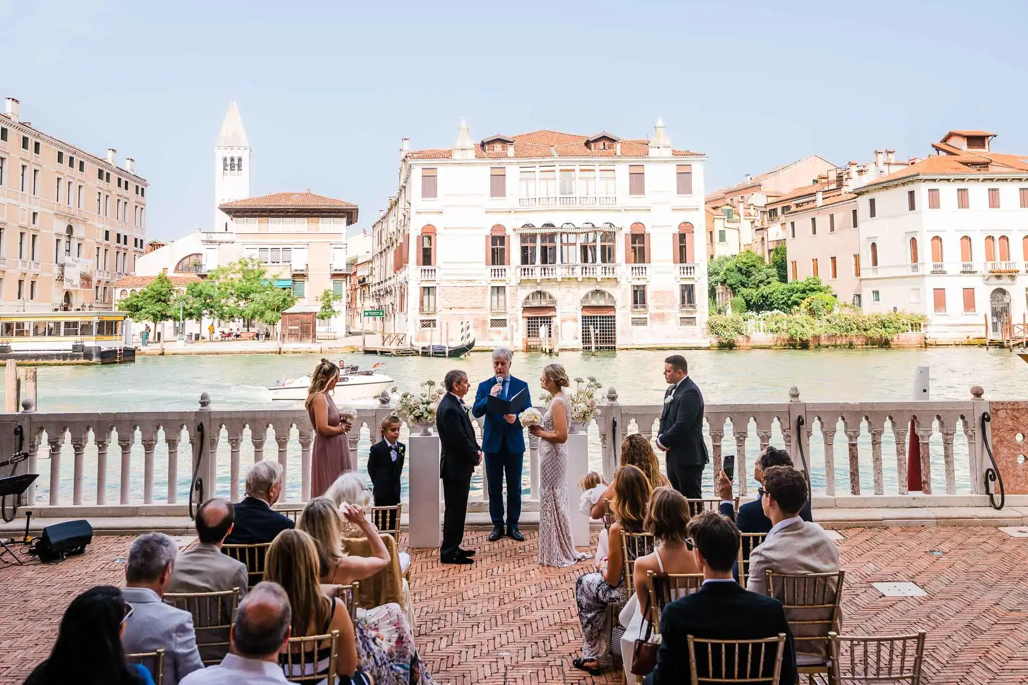 Venezia wedding ceremony by the canal with bride, groom, and officiant in Venice Italy.