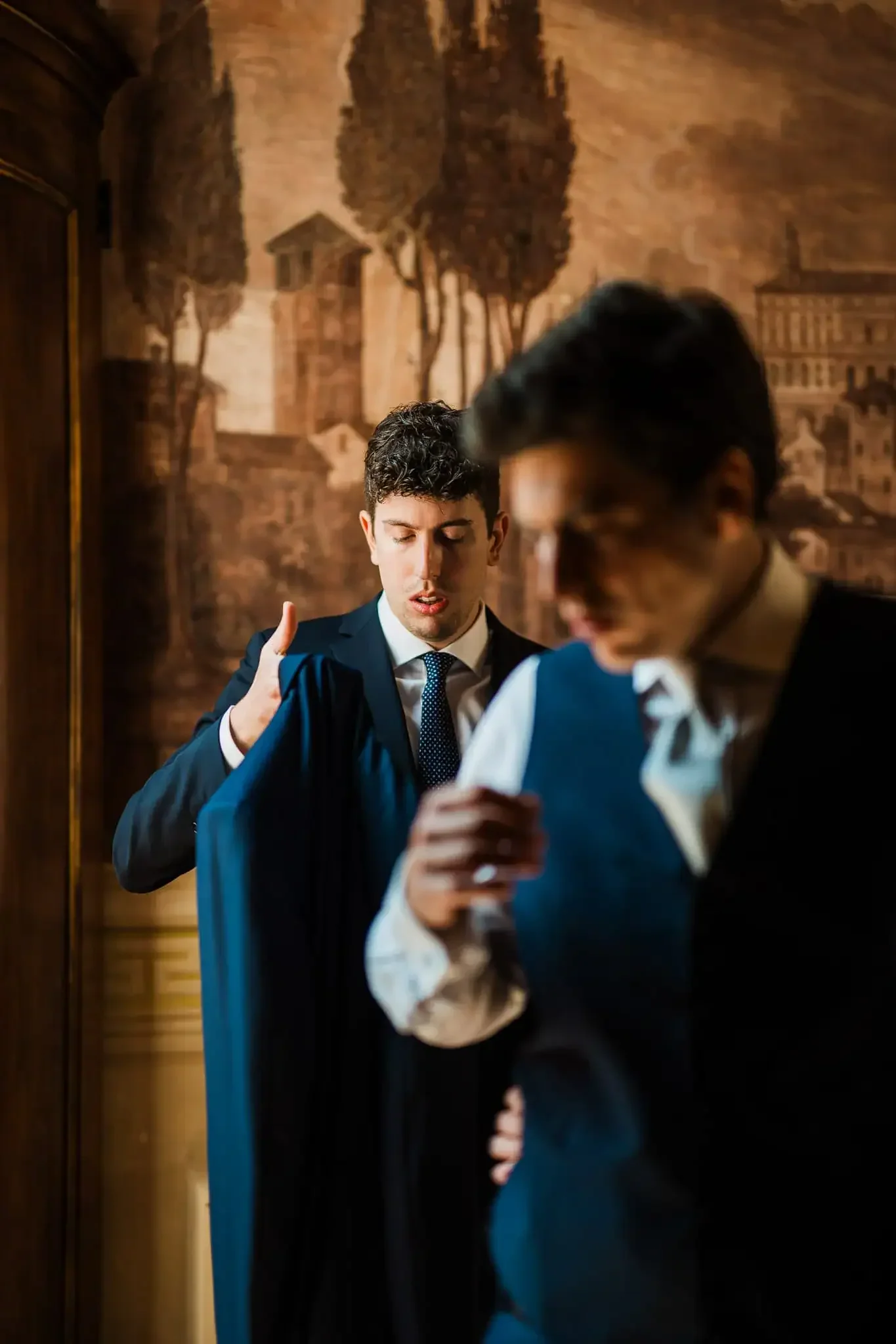 Elegant groom adjusting suit in Venice for wedding or engagement photoshoot.