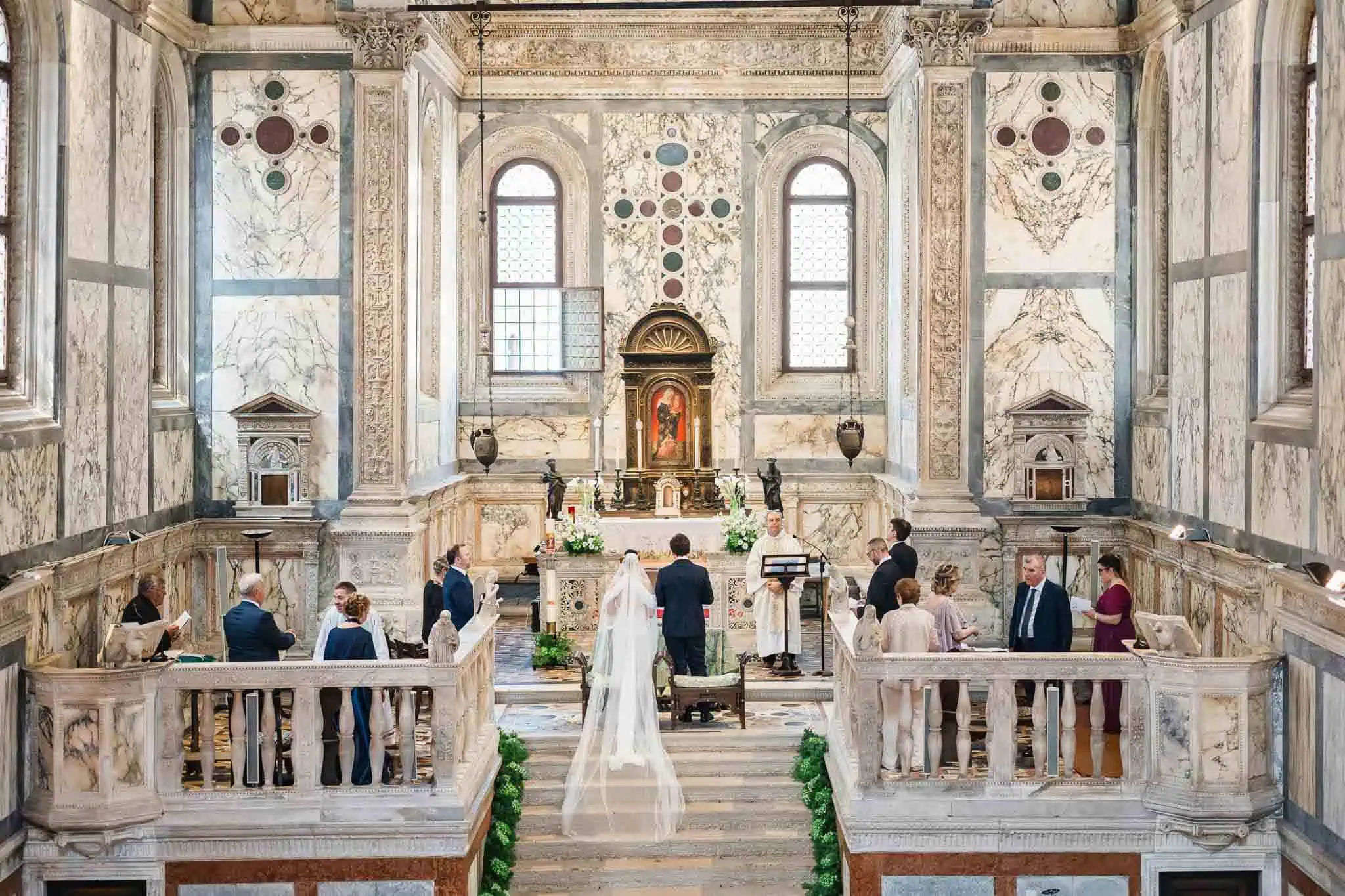 Elegant Venice wedding ceremony inside historic church with marble walls and high windows.